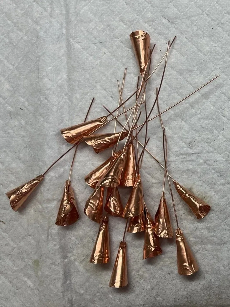 Tiny jingles are being made for the "Jingle Dress Dancer" sculpture from copper.