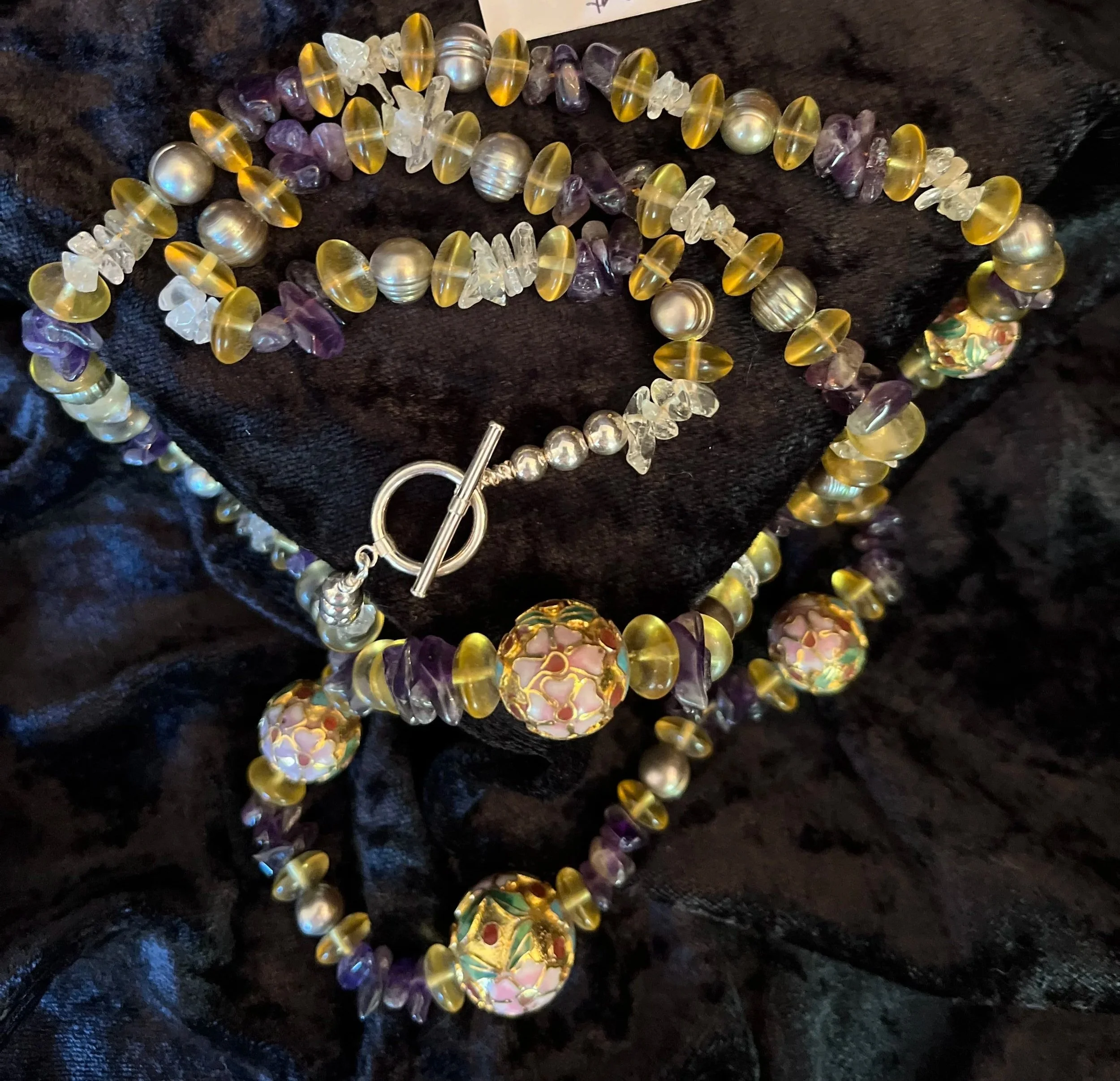 Necklace with sterling clasp. Colonnaise beads. Natural amethyst and citrine stones on a blue background.