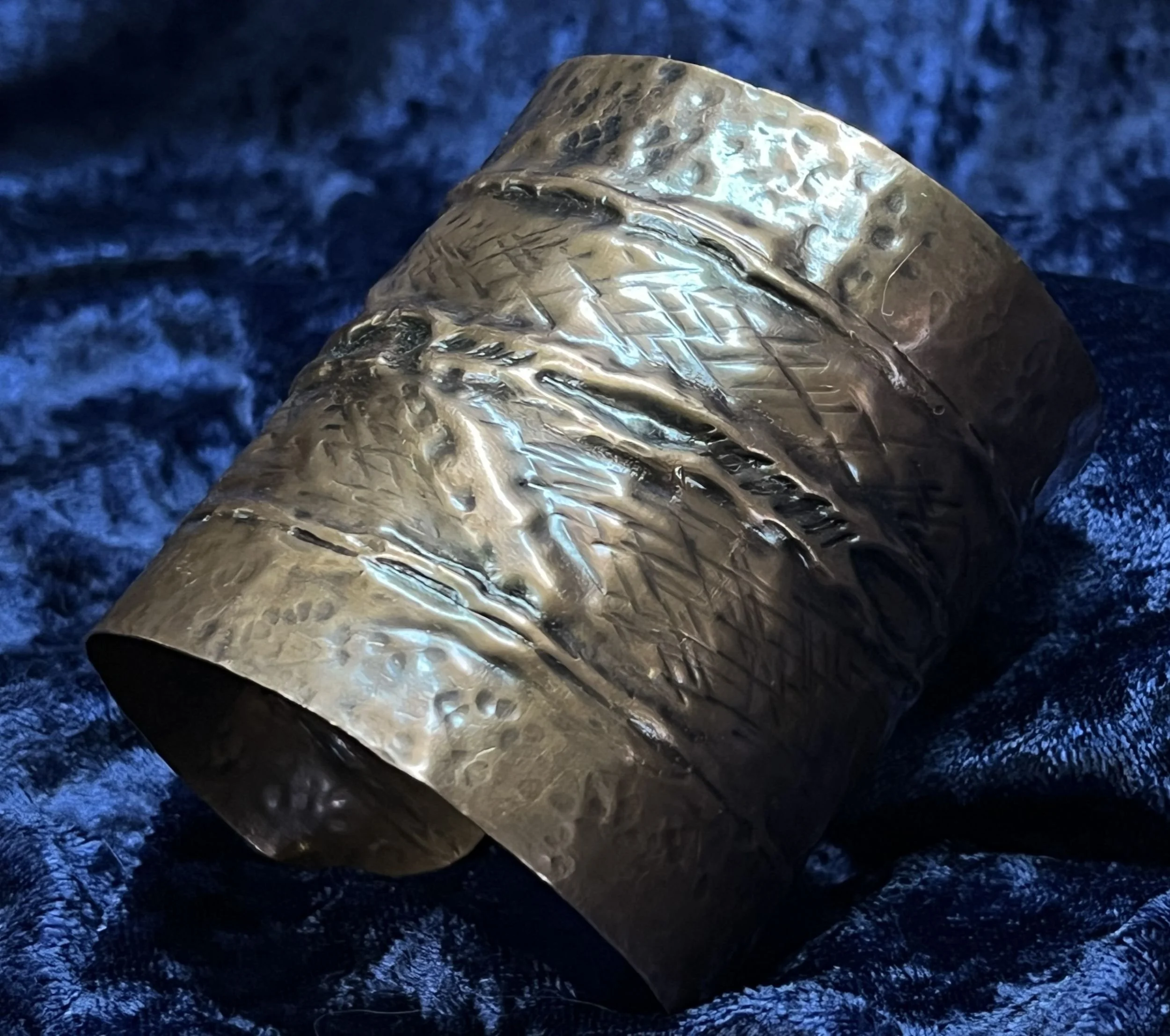 Copper bracelet laying on a blue background.