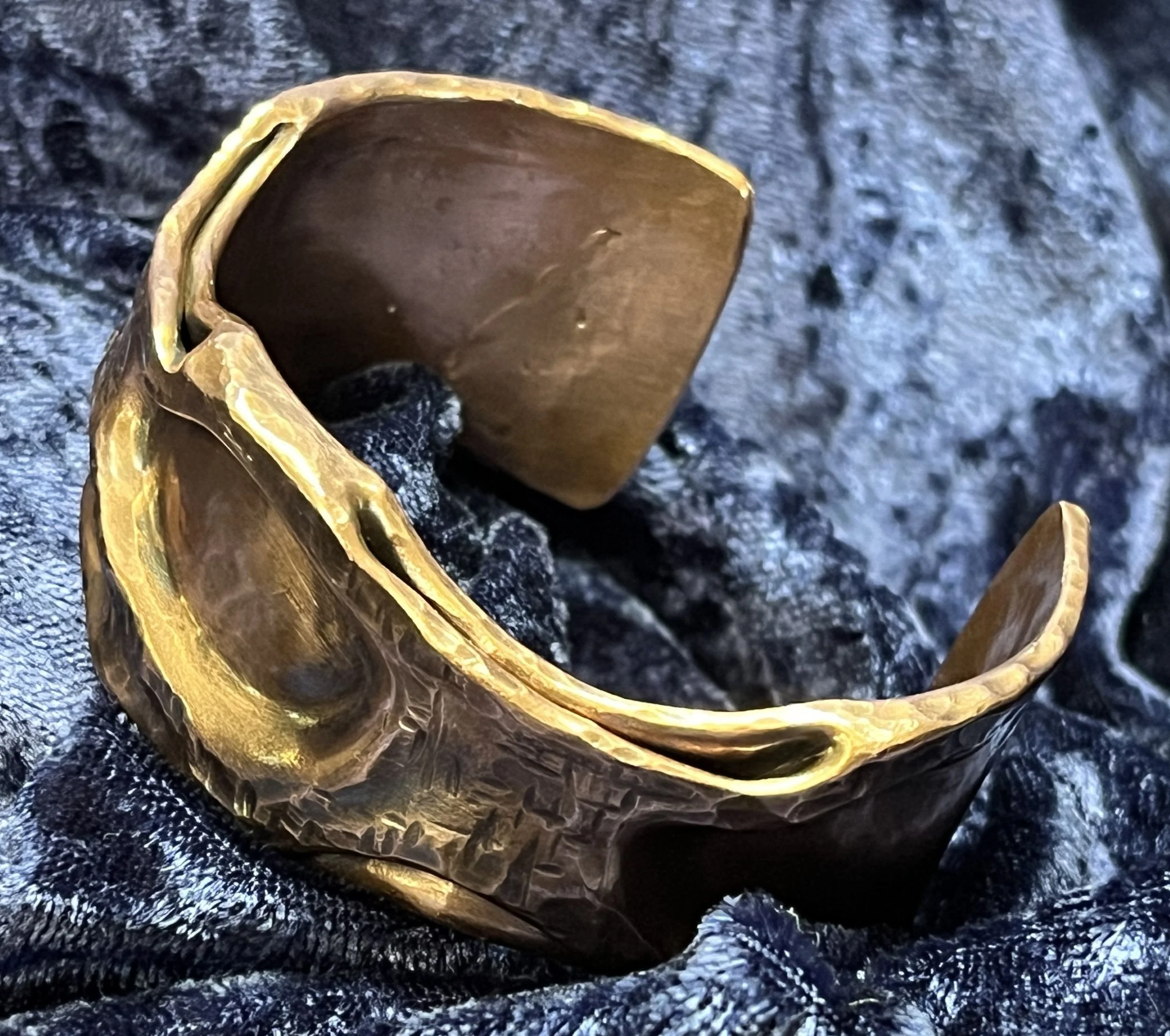 Copper bracelet laying on a blue background.
