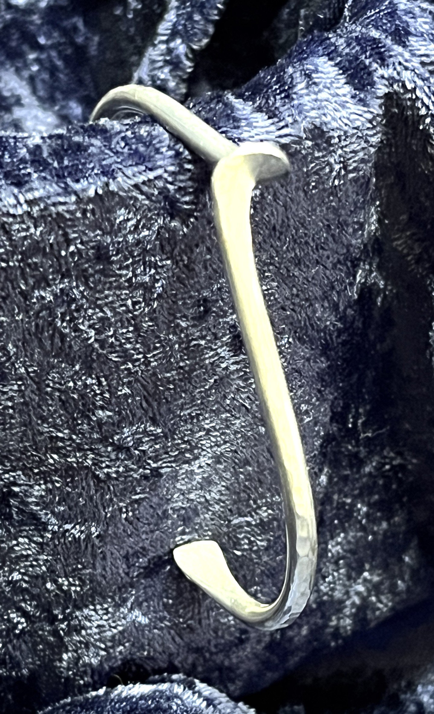 Sterling silver bracelet laying on a blue background.