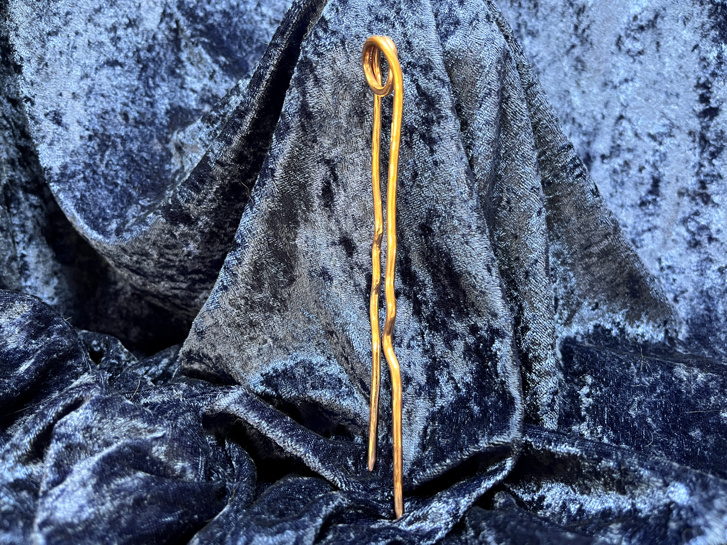Hair stick laying on a blue background.