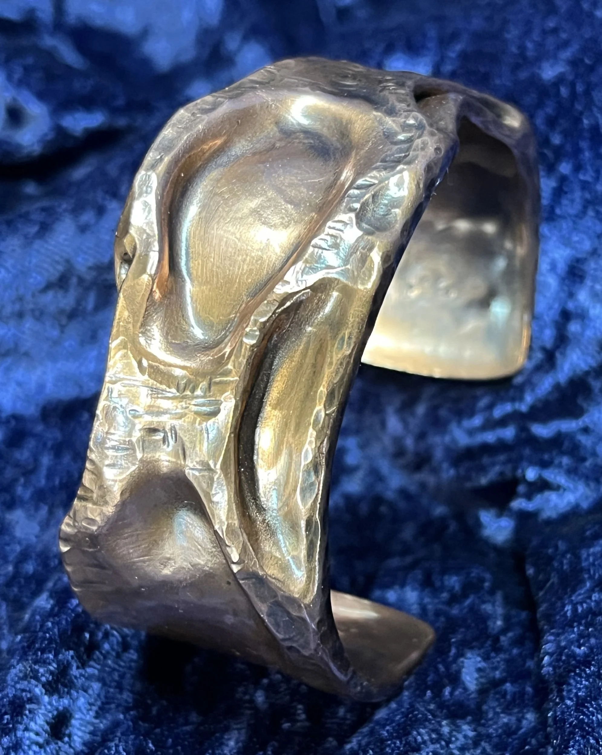 Copper bracelet laying on a blue background.