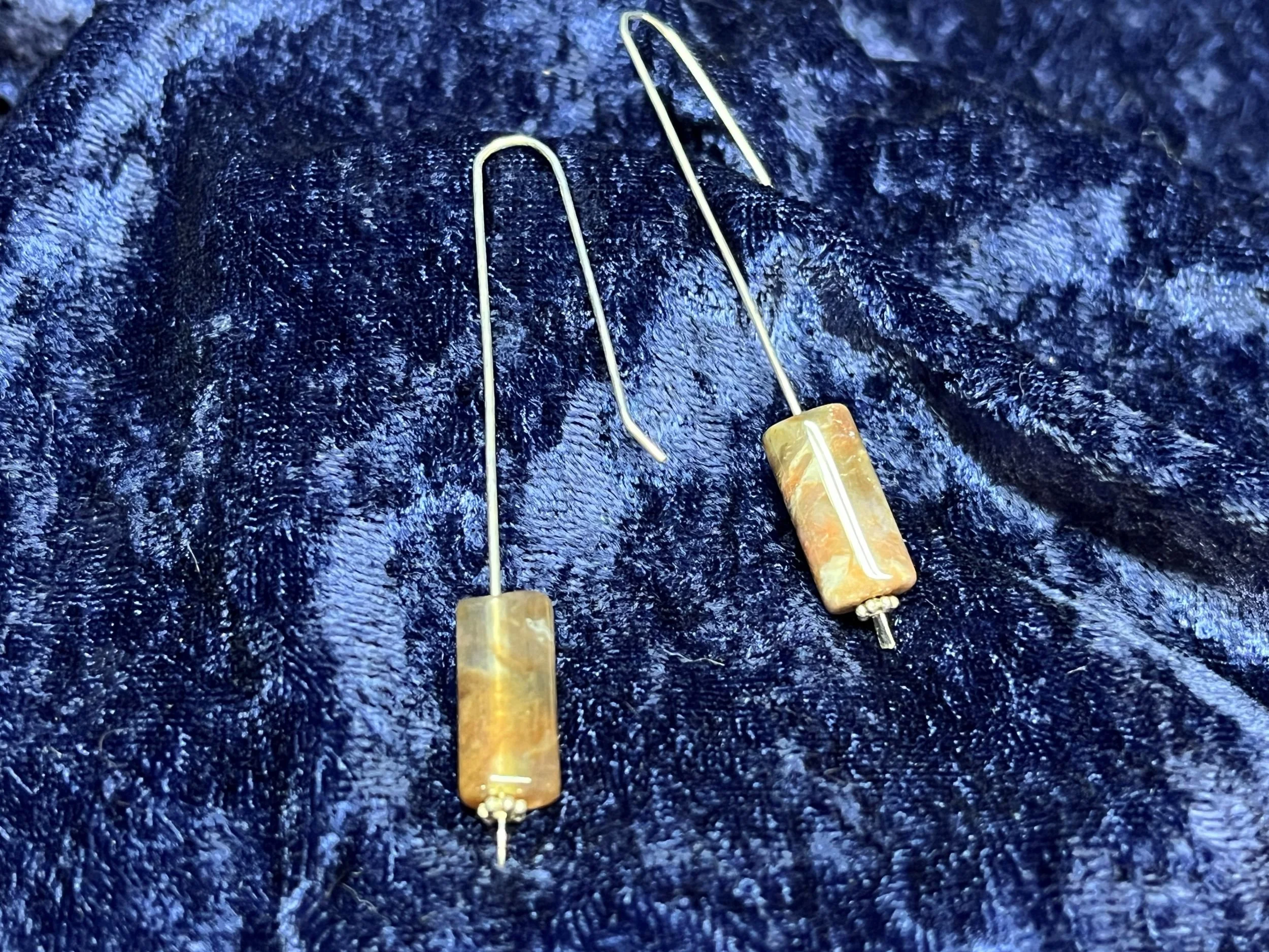 Earrings hanging on a blue background.
