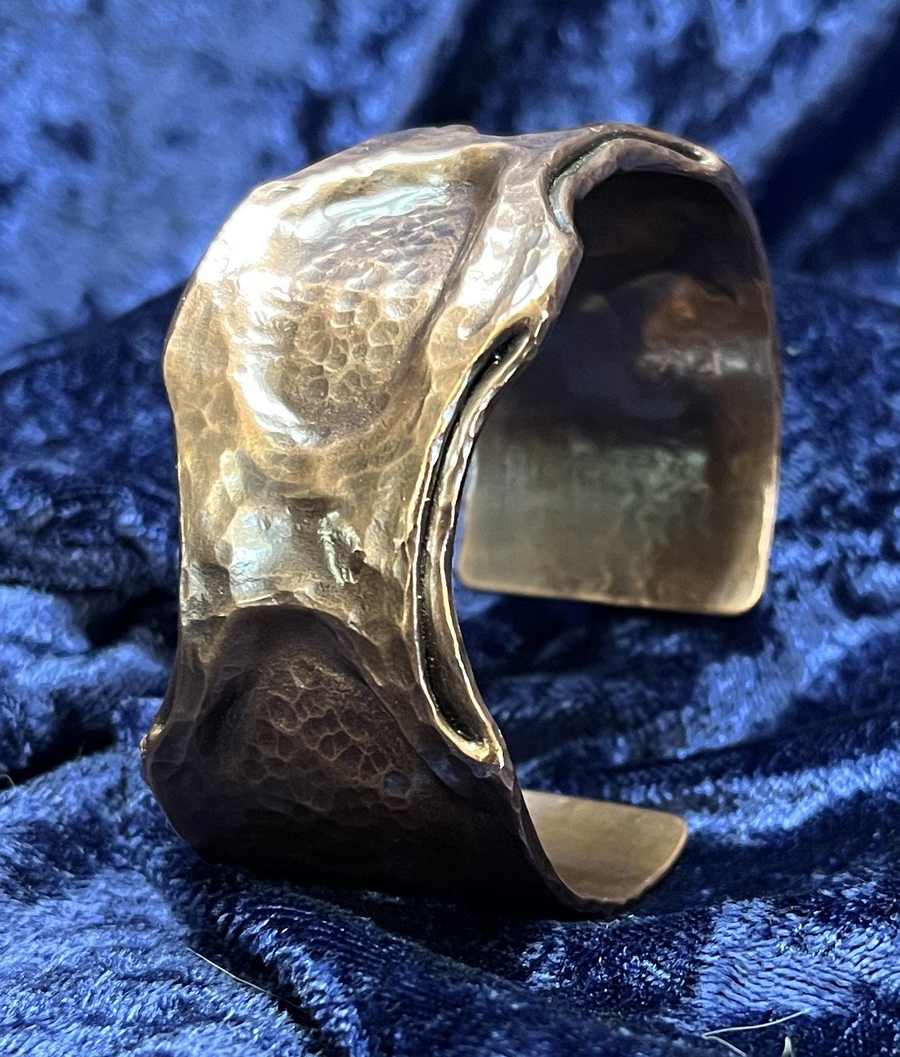 Copper bracelet laying on a blue background.