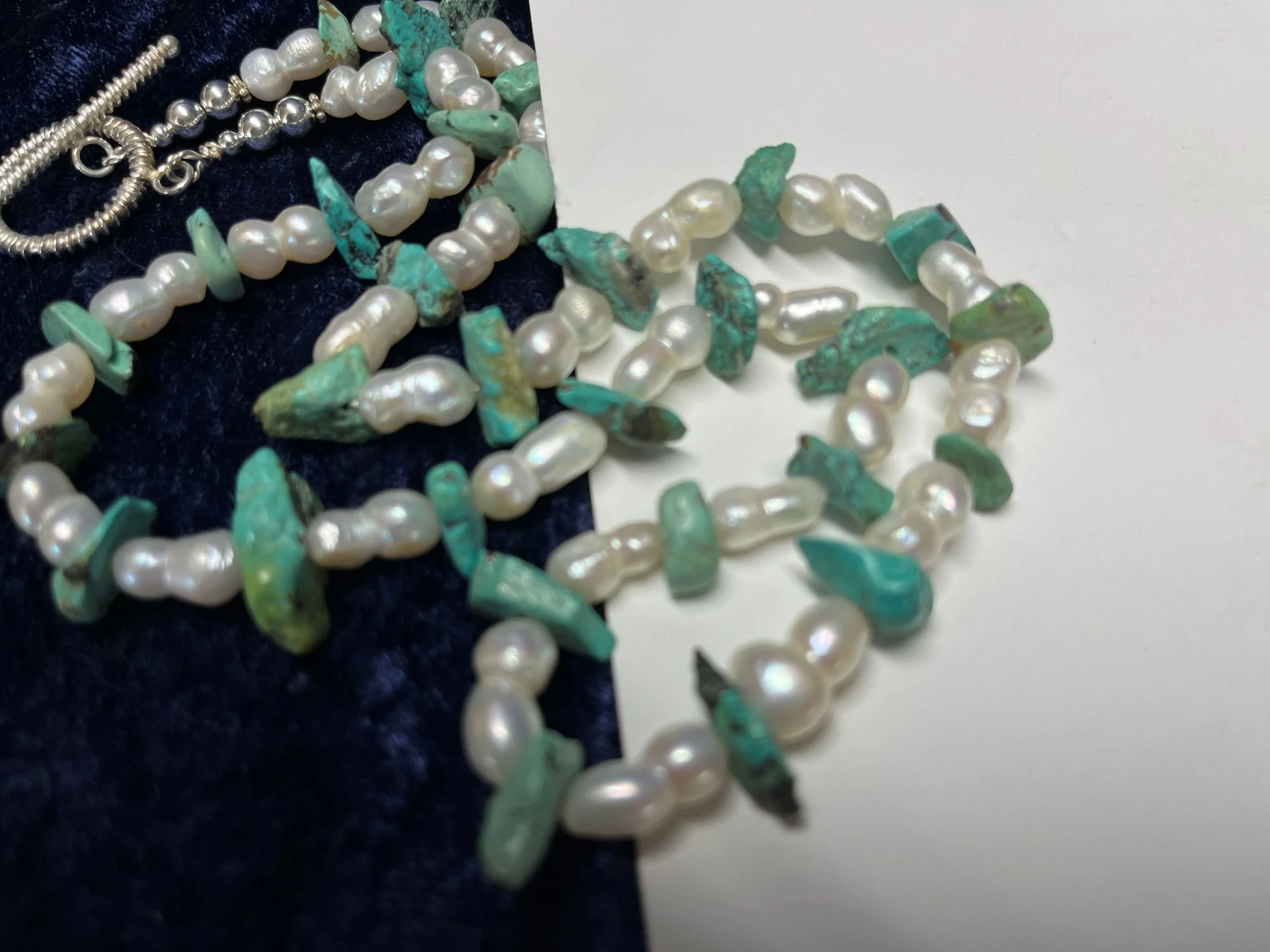 Necklace laying on a blue background.