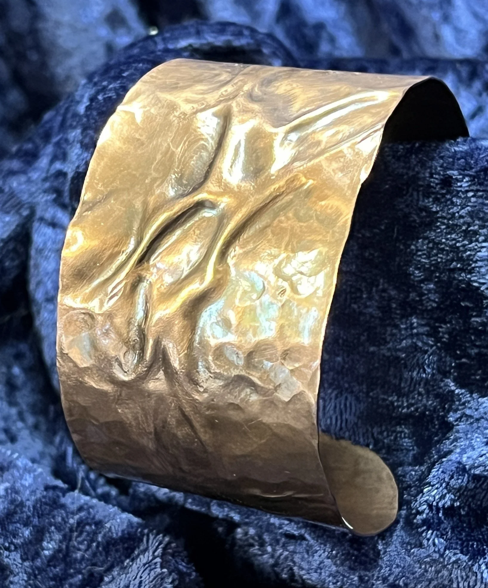 Copper bracelet laying on a blue background.