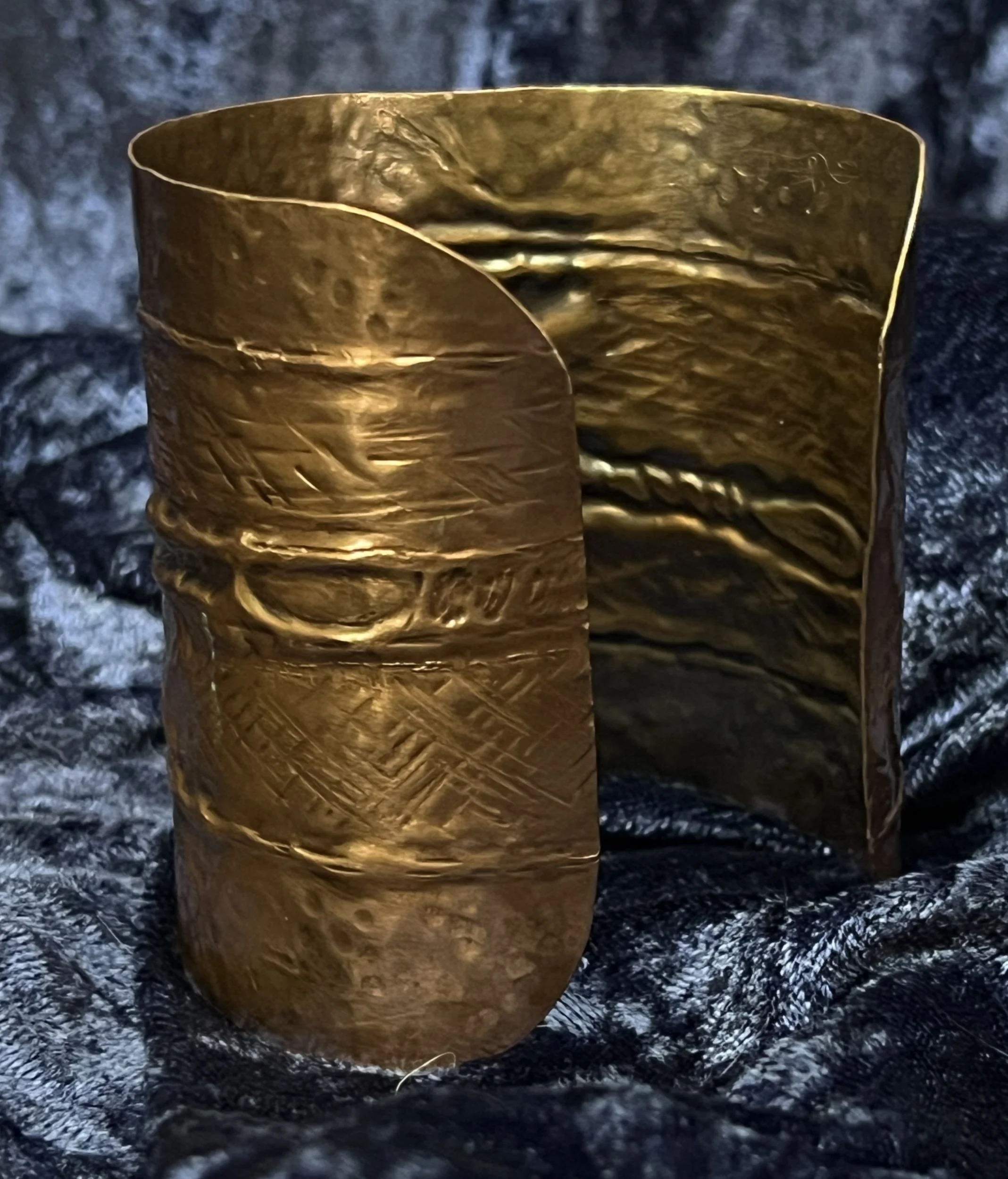 Copper bracelet laying on a blue background.