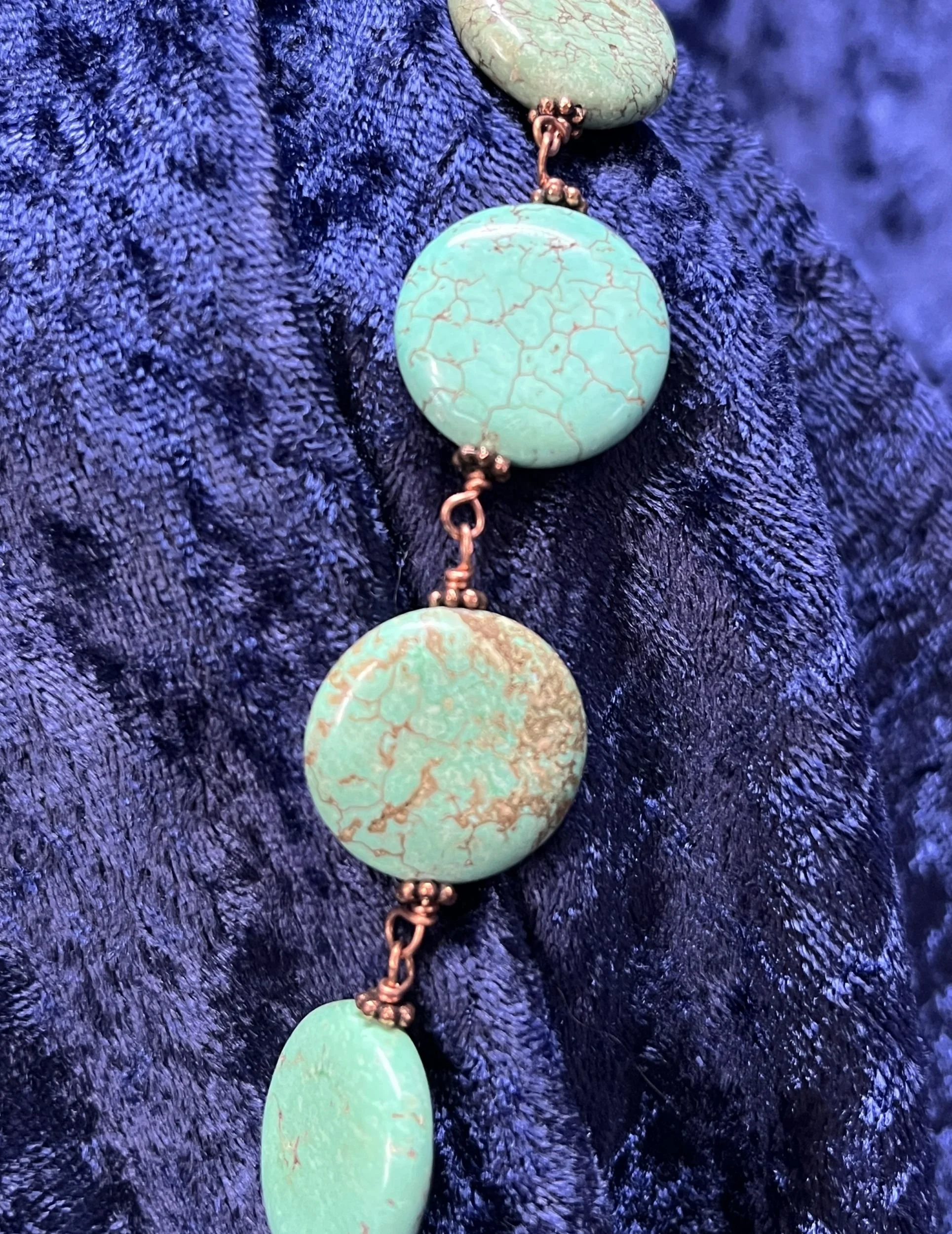 Necklace laying on a blue background.