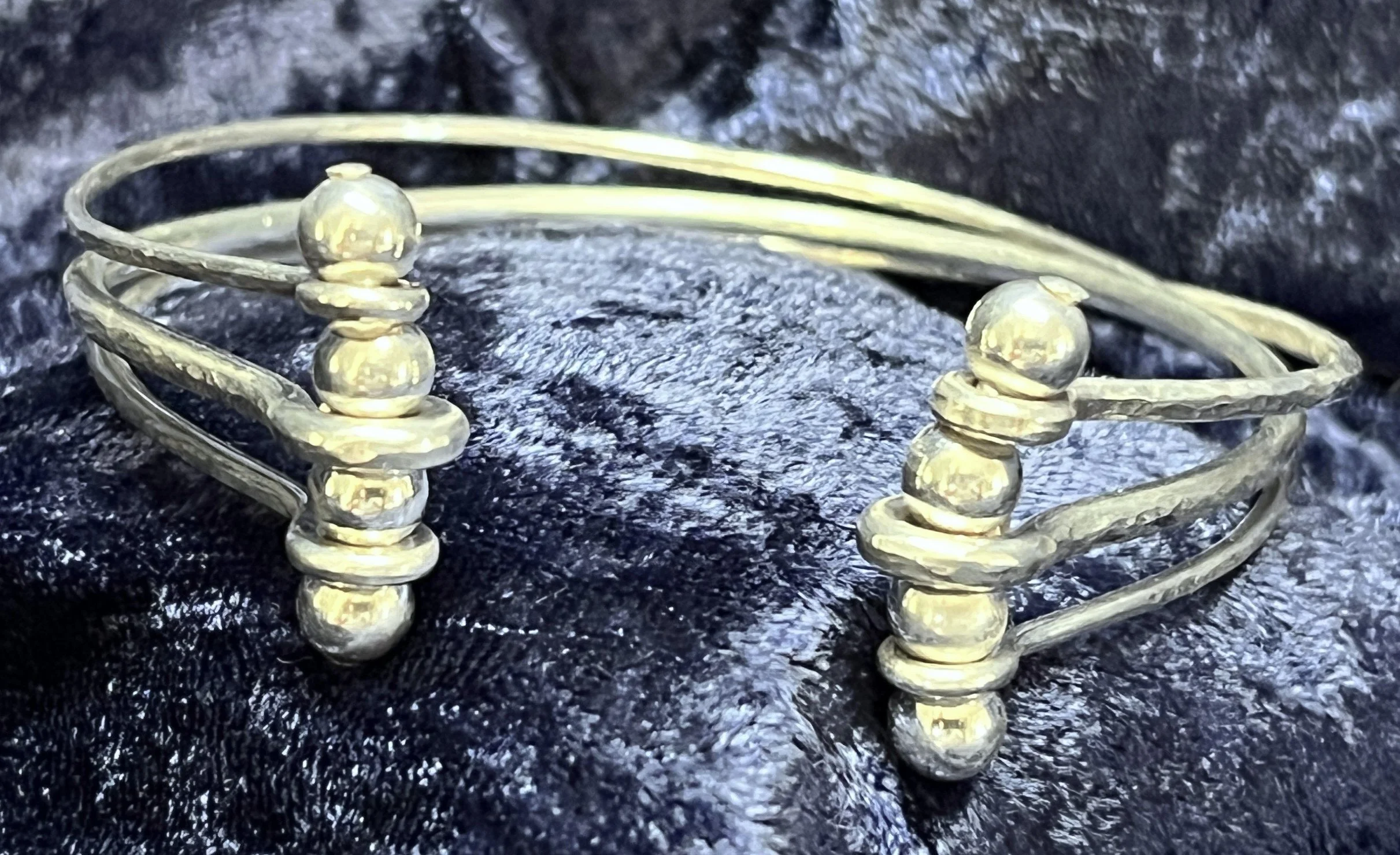 Sterling silver bracelet laying on a blue background.