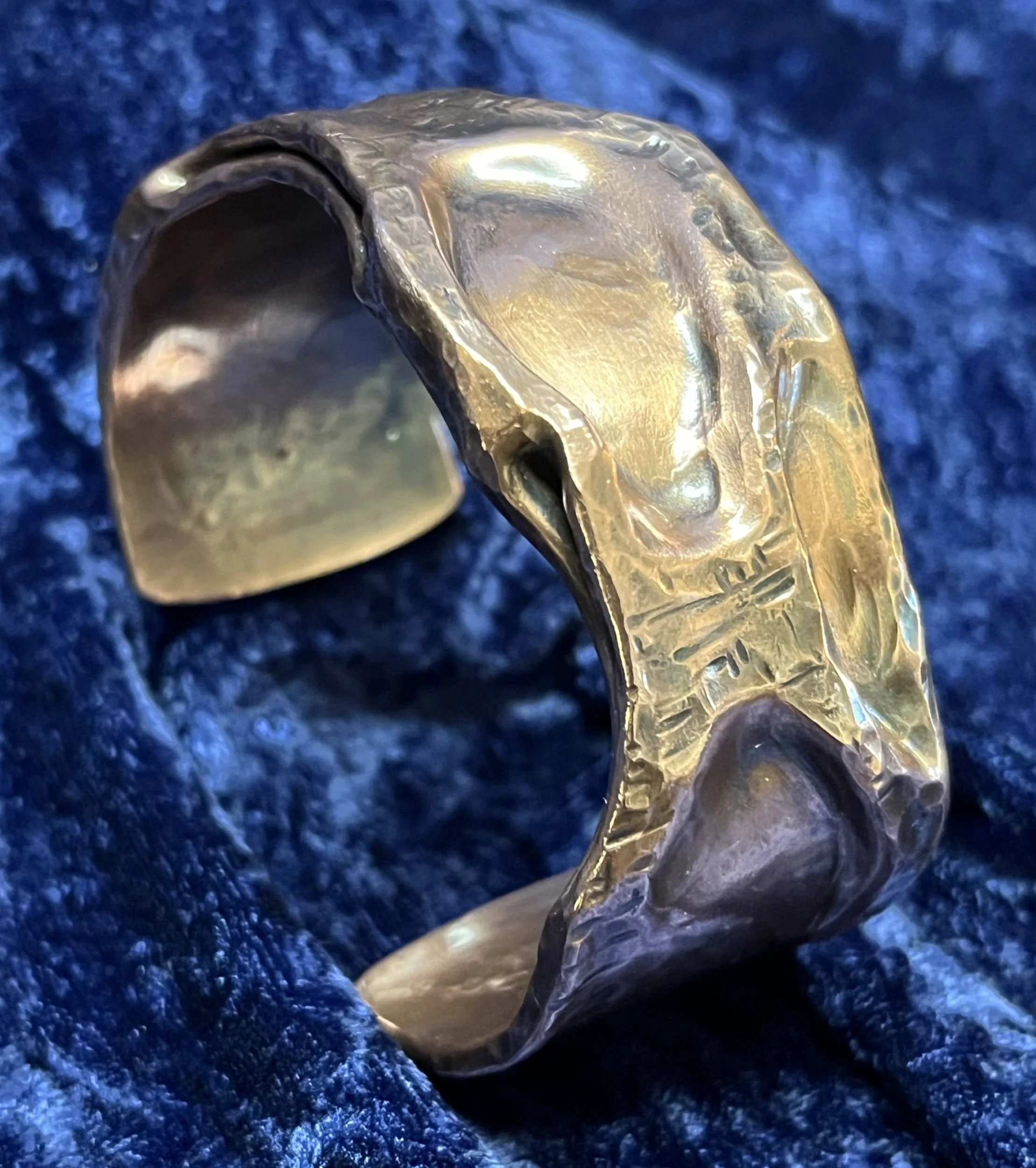 Copper bracelet laying on a blue background.