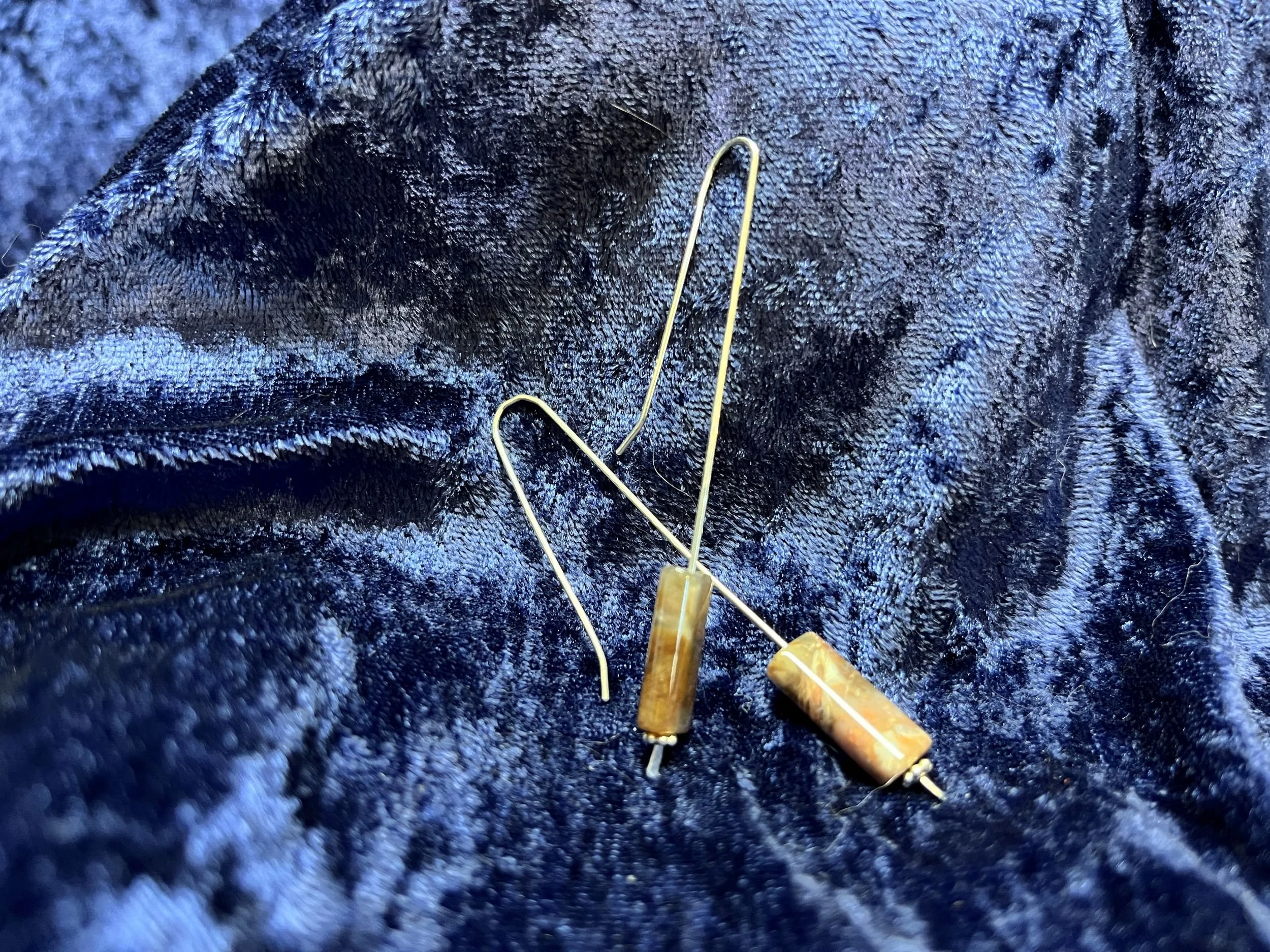 Earrings hanging on a blue background.