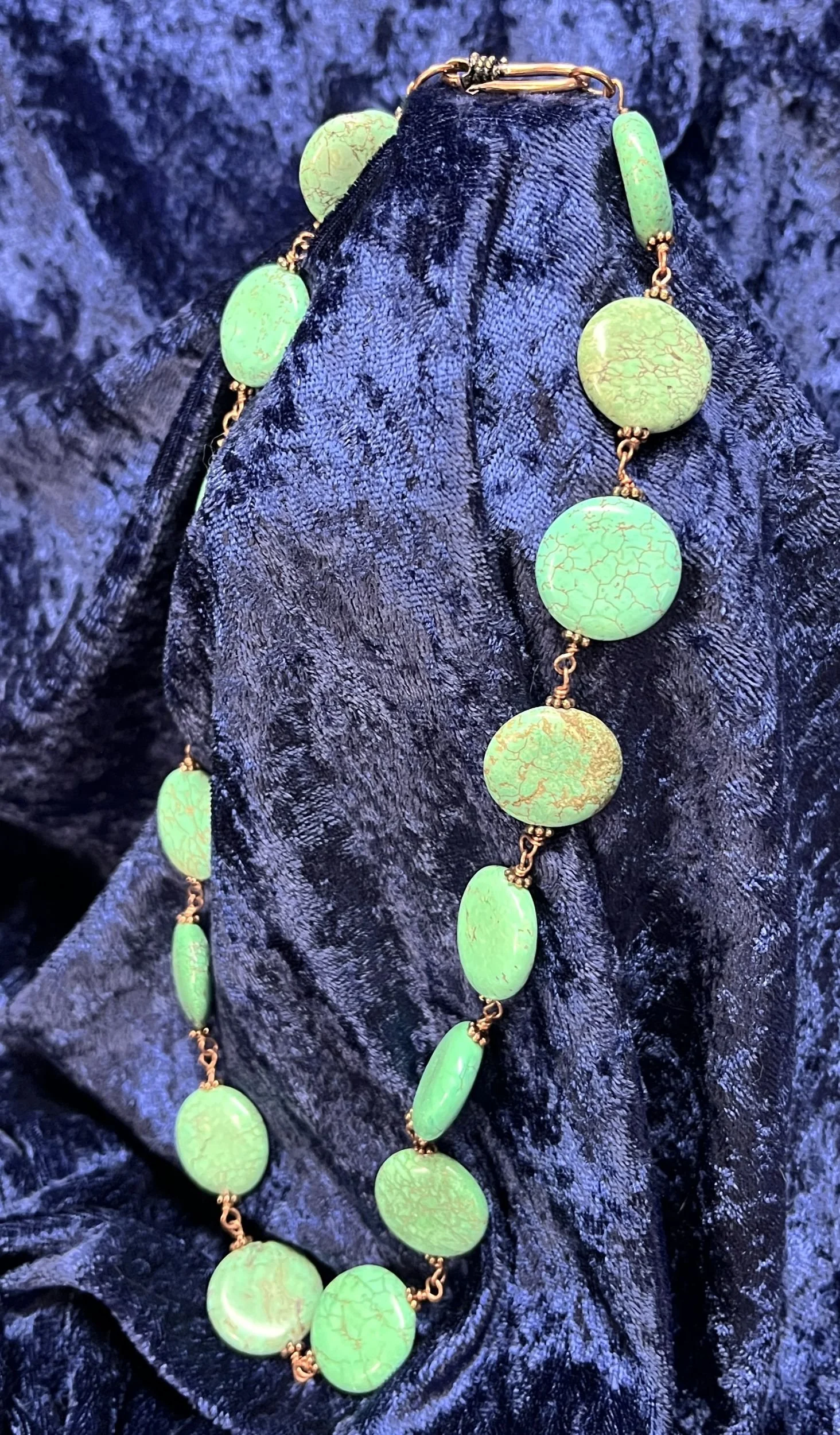 Necklace laying on a blue background.