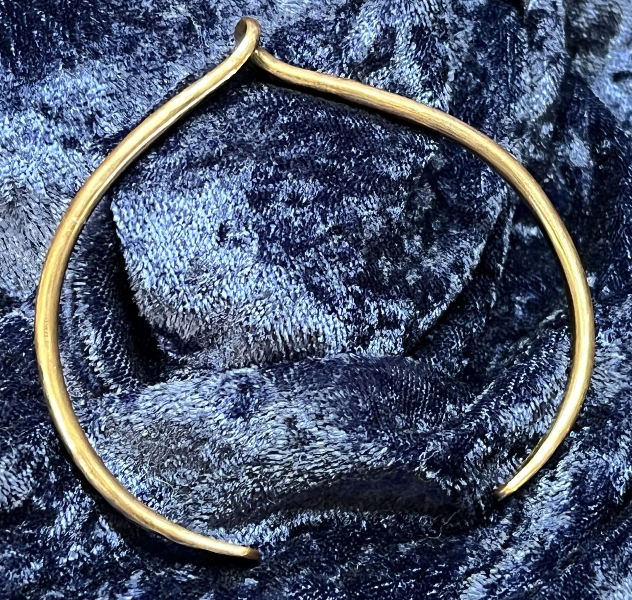 Hand-Forged Copper Twist Cuff Bracelet on blue background