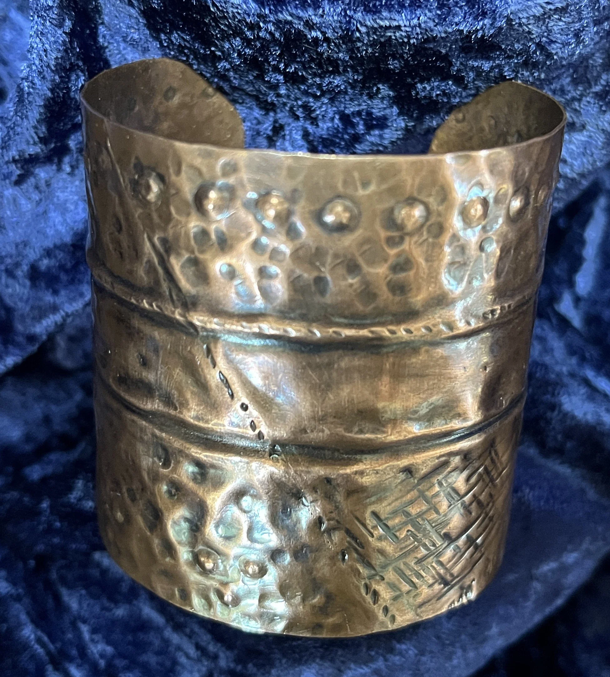 Copper bracelet laying on a blue background.