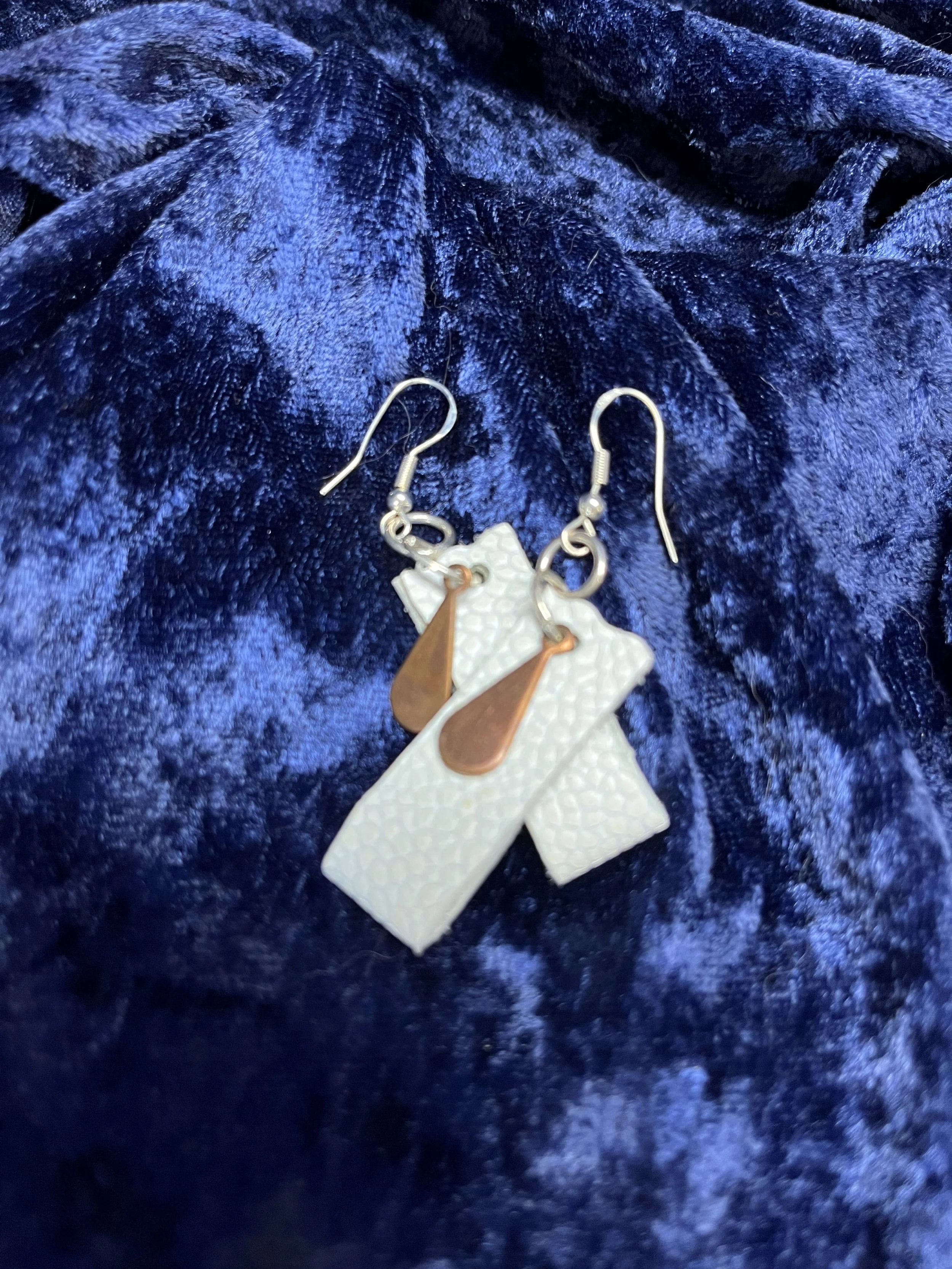 Earrings hanging on a blue background.