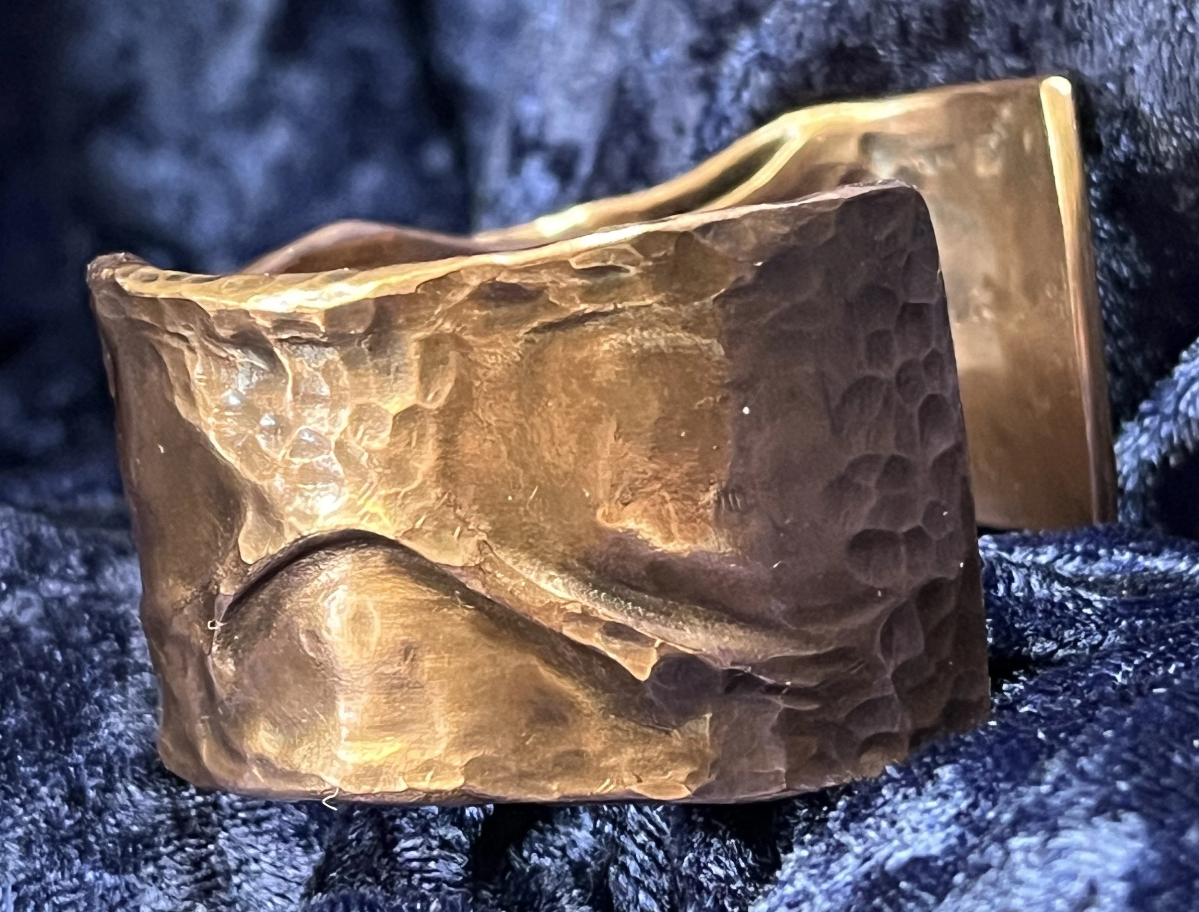 Copper bracelet laying on a blue background.