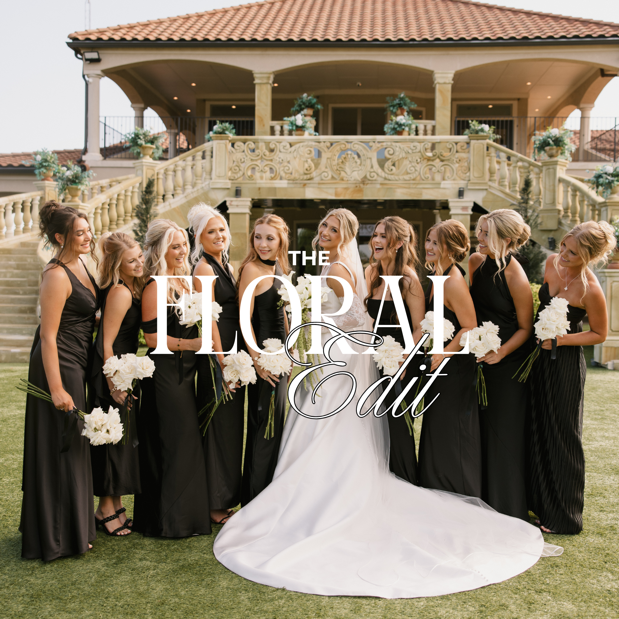 Group of women dressed in formal black gowns standing outside a large ornate house with a red tile roof, floral decorations, and a white wedding dress with a long train.