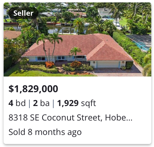 A large single-story house with a red-tiled roof, surrounded by palm trees and greenery, situated in a tropical neighborhood.