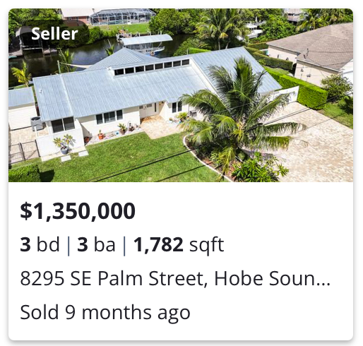 Aerial view of a white house with a metal roof, palm trees, and a waterway in the background, listed for sale at $1,350,000 with 3 bedrooms and 3 bathrooms, located on SE Palm Street in Hobe Sound, Florida.