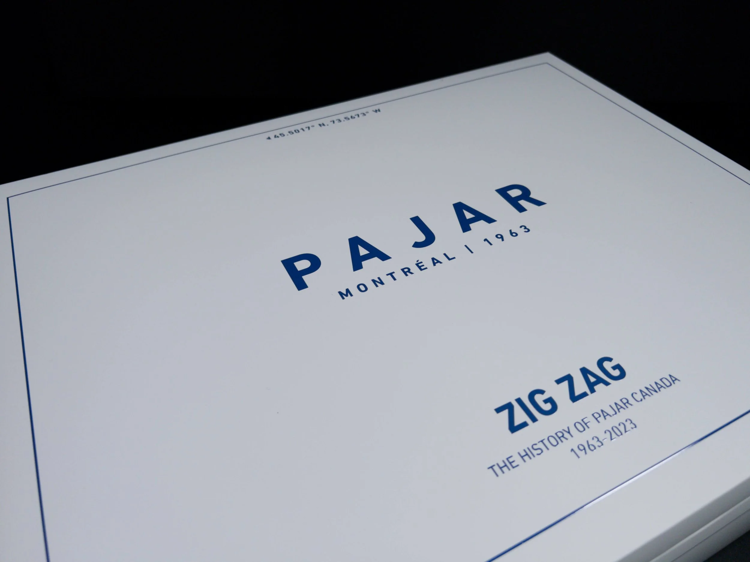 Close-up of a printed map with the word 'Pajar' in blue, and the coordinates 45.5017° N, 73.5673° W at the top, against a black background.