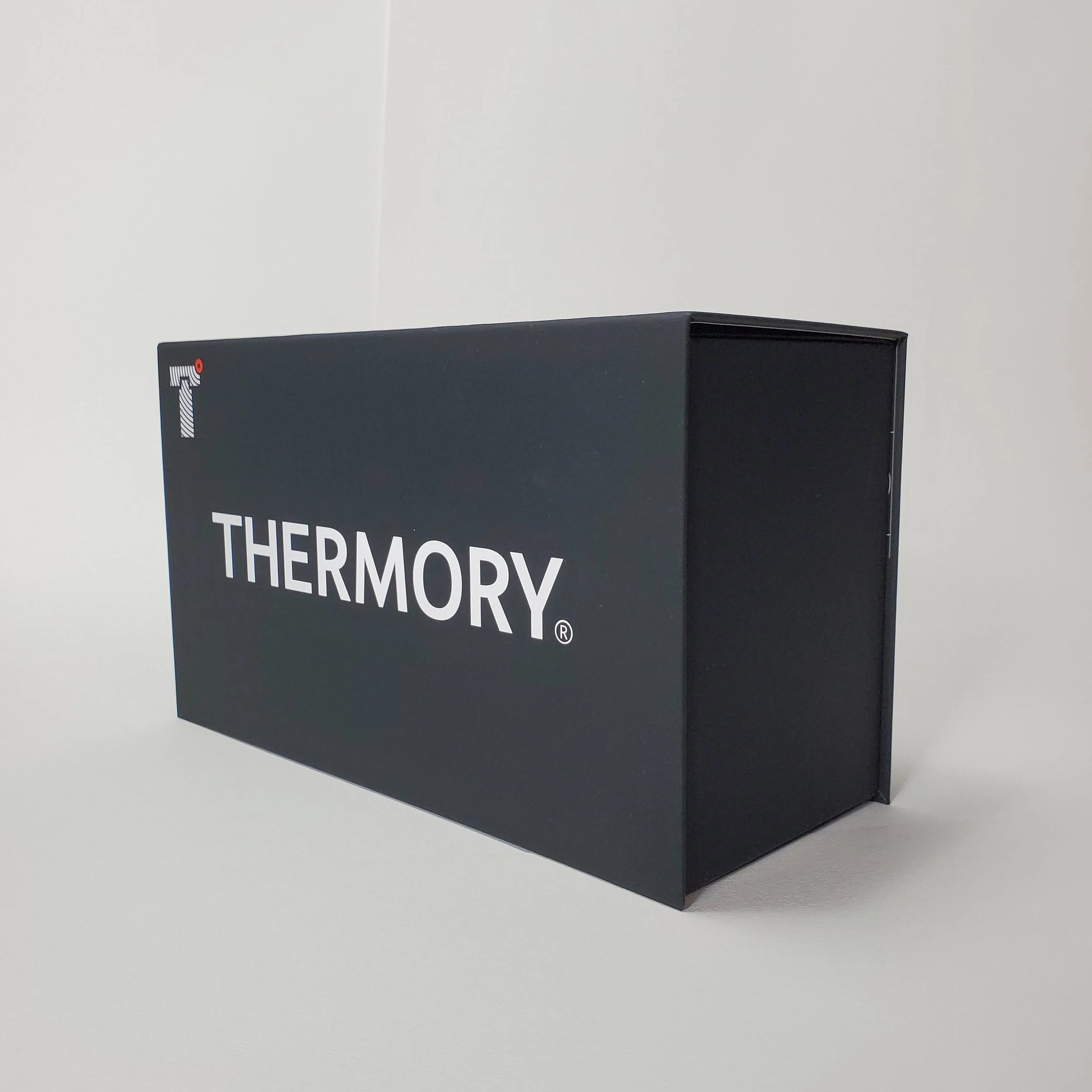 Close-up of a black sign with white text reading 'THERMOGRAPHY' against a plain white background.