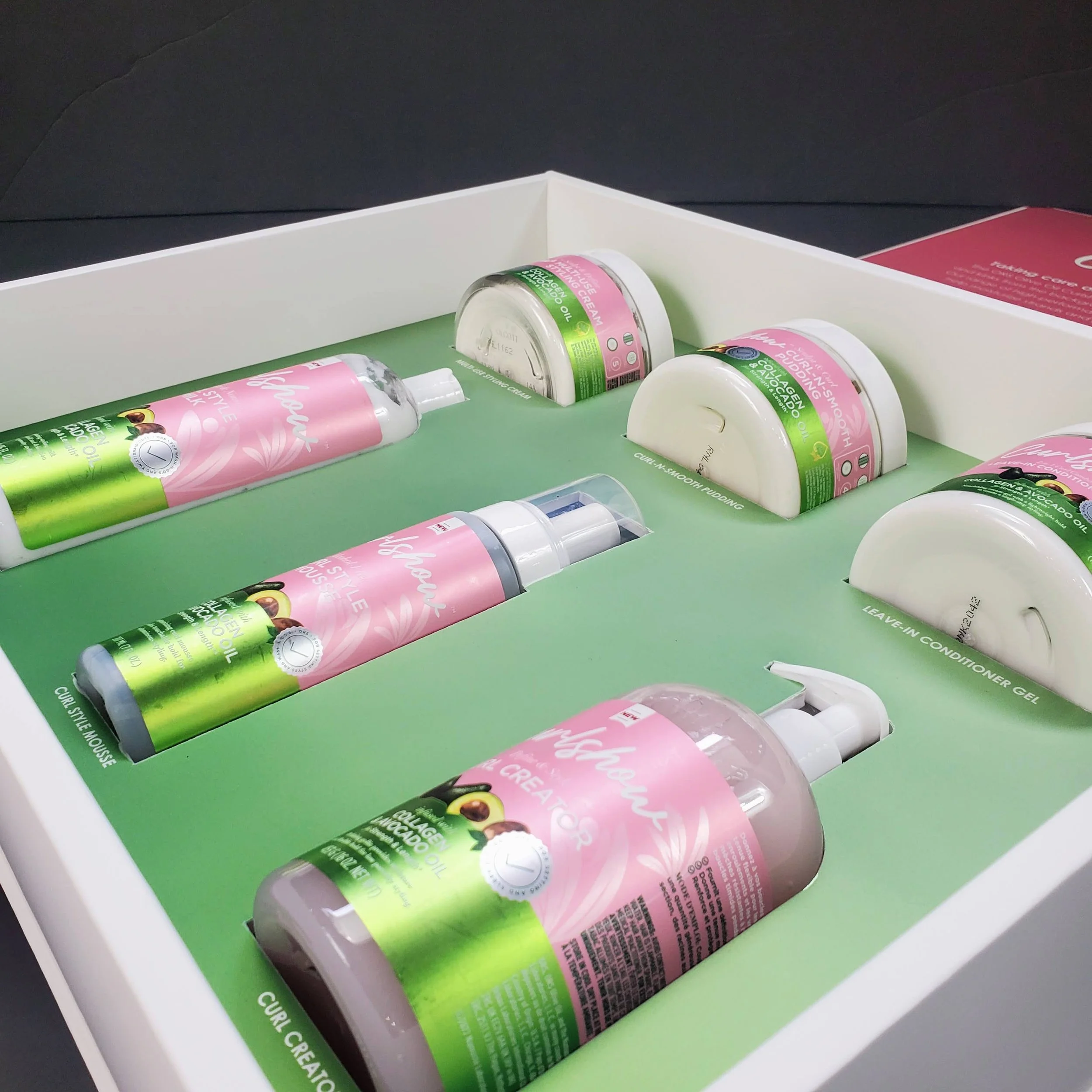 Display of various containers of collagen and avocado oil skincare products in a white box with a green interior.