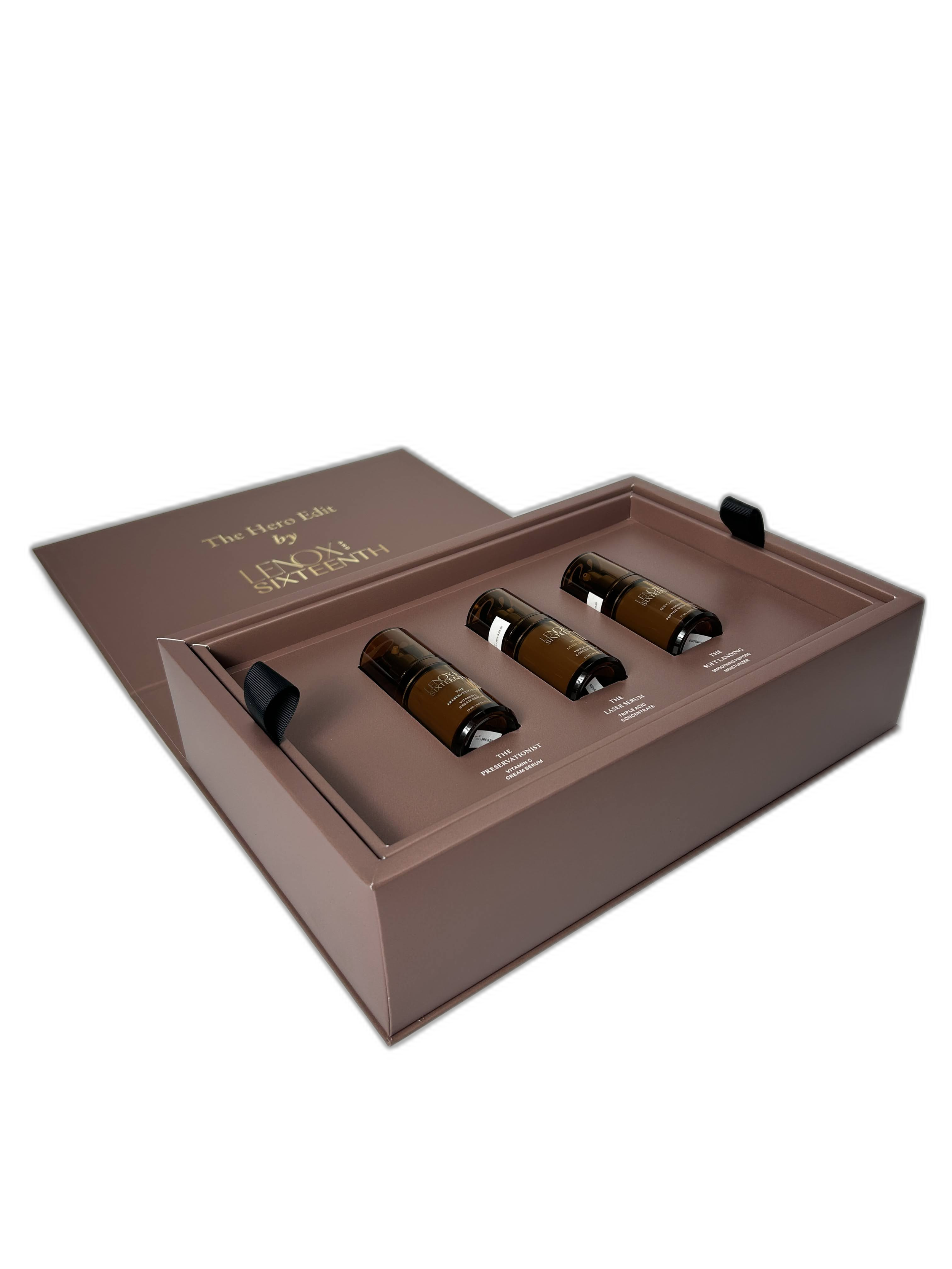A boxed set of skincare products called 'The Hero Set by LanoSixteenth,' containing four bottles arranged in a pink box with labeled compartments for each product.