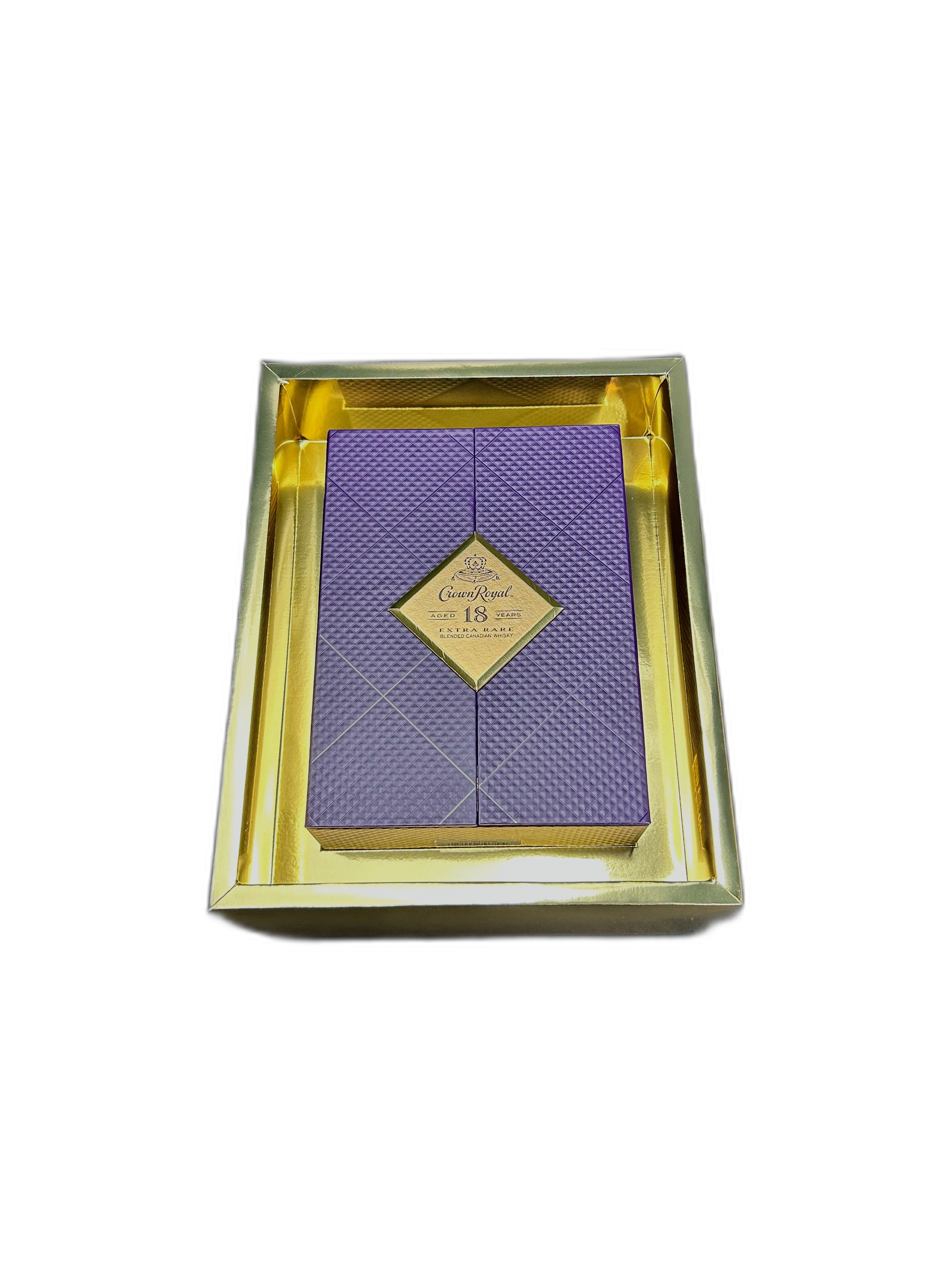 A purple box with a diamond-shaped label that reads 'Crown Royal 18 Years Extra Rare Blended Canadian Whisky' is displayed inside a reflective gold box against a black background.