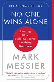 Book cover of "No One Wins Alone" by Mark Messier, featuring a blue background, white title, and red circle with subtitle about leading and inspiring greatness.