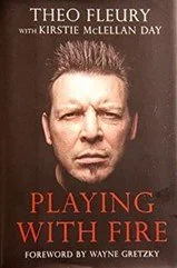Book cover of "Playing with Fire" featuring a close-up of Theo Fleury's face with serious expression, dark background, and red and white text.