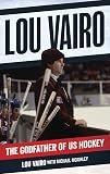 Lou Vairo speaking at a hockey event, with a sign behind him that reads 'Lou Vairo' and another sign saying 'The Godfather of US Hockey'.