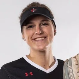 Smiling woman wearing a black sports cap and black athletic shirt, holding a football.