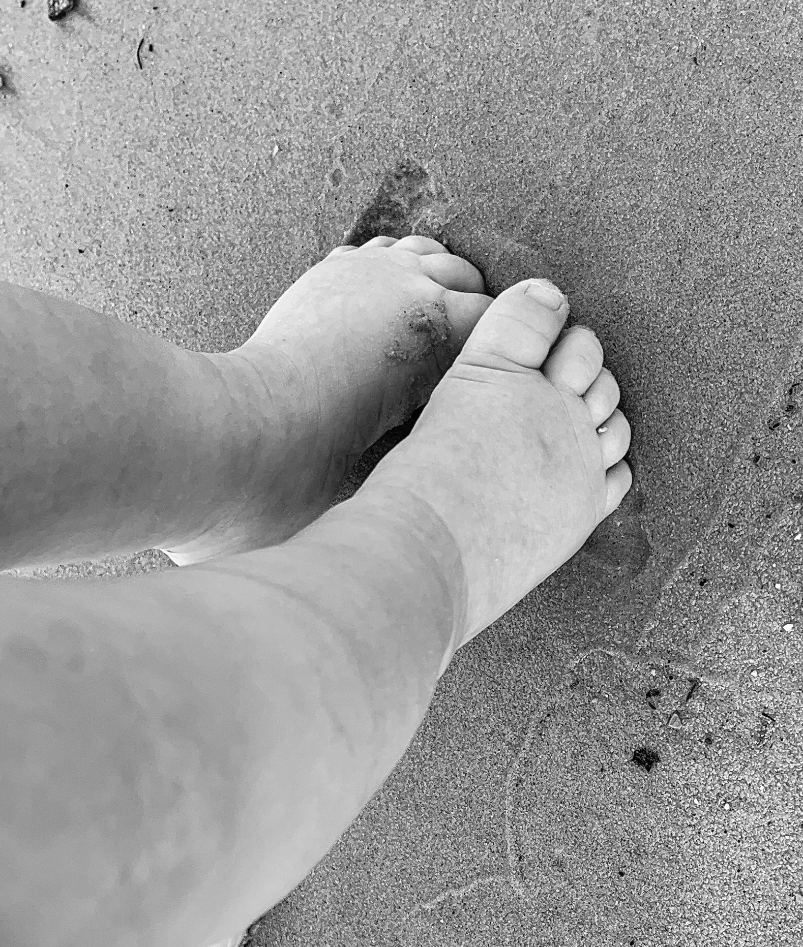 A baby's feet in the sand, representing the first steps of a child's journey with Rooted Kids Therapy.