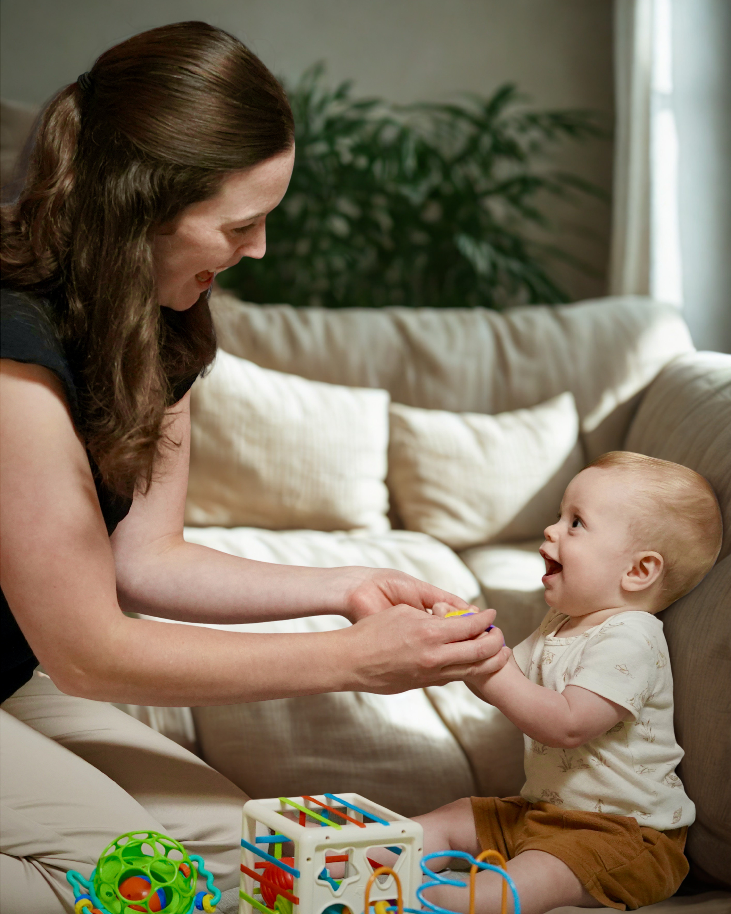 Pediatric occupational therapist smiling and playing with a young child during an in-home OT session in Mountain Home, AR.