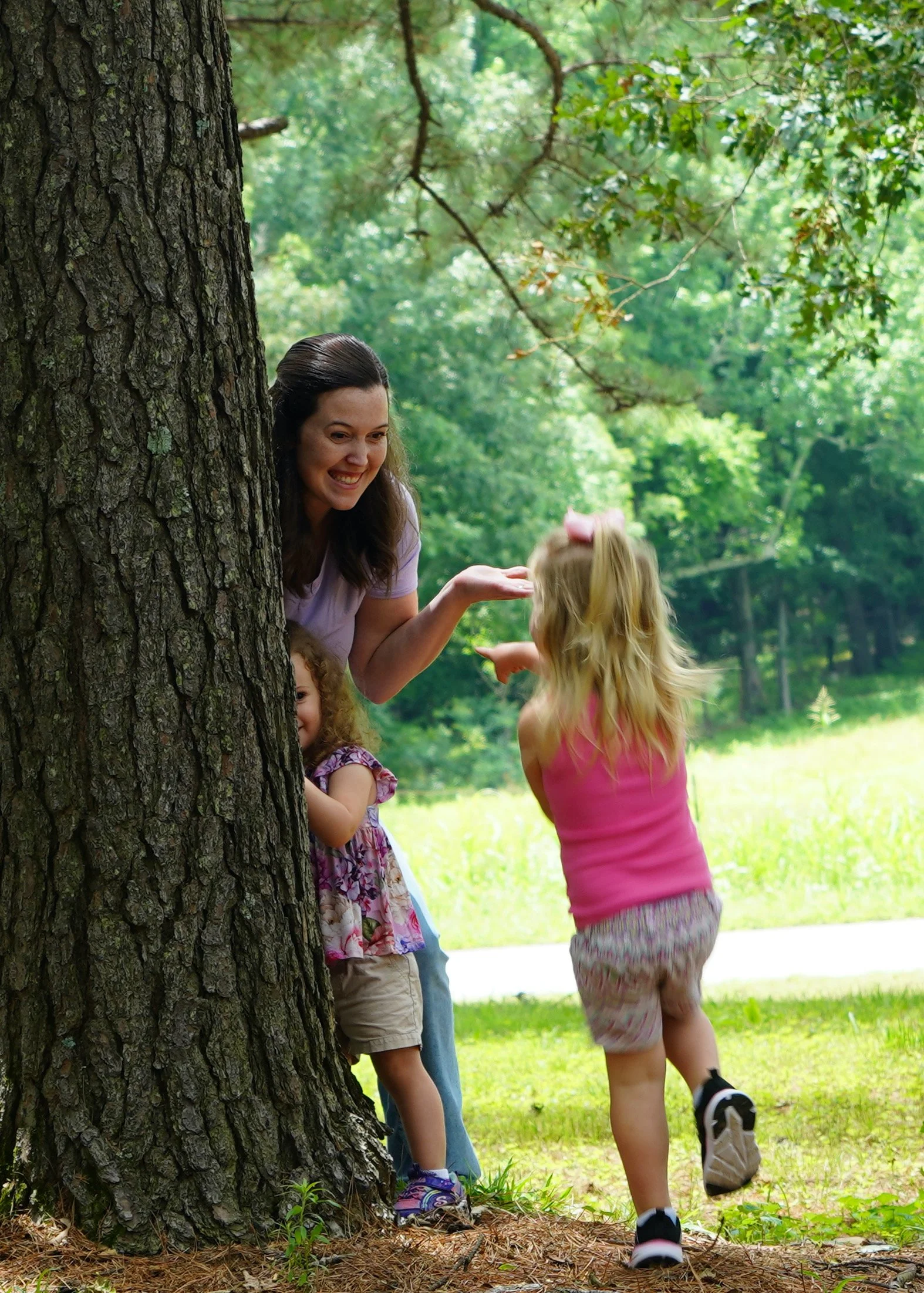 Children and a therapist playing outdoors around a tree during an outdoor-based Grow Groups enrichment session at Rooted Kids Therapy.