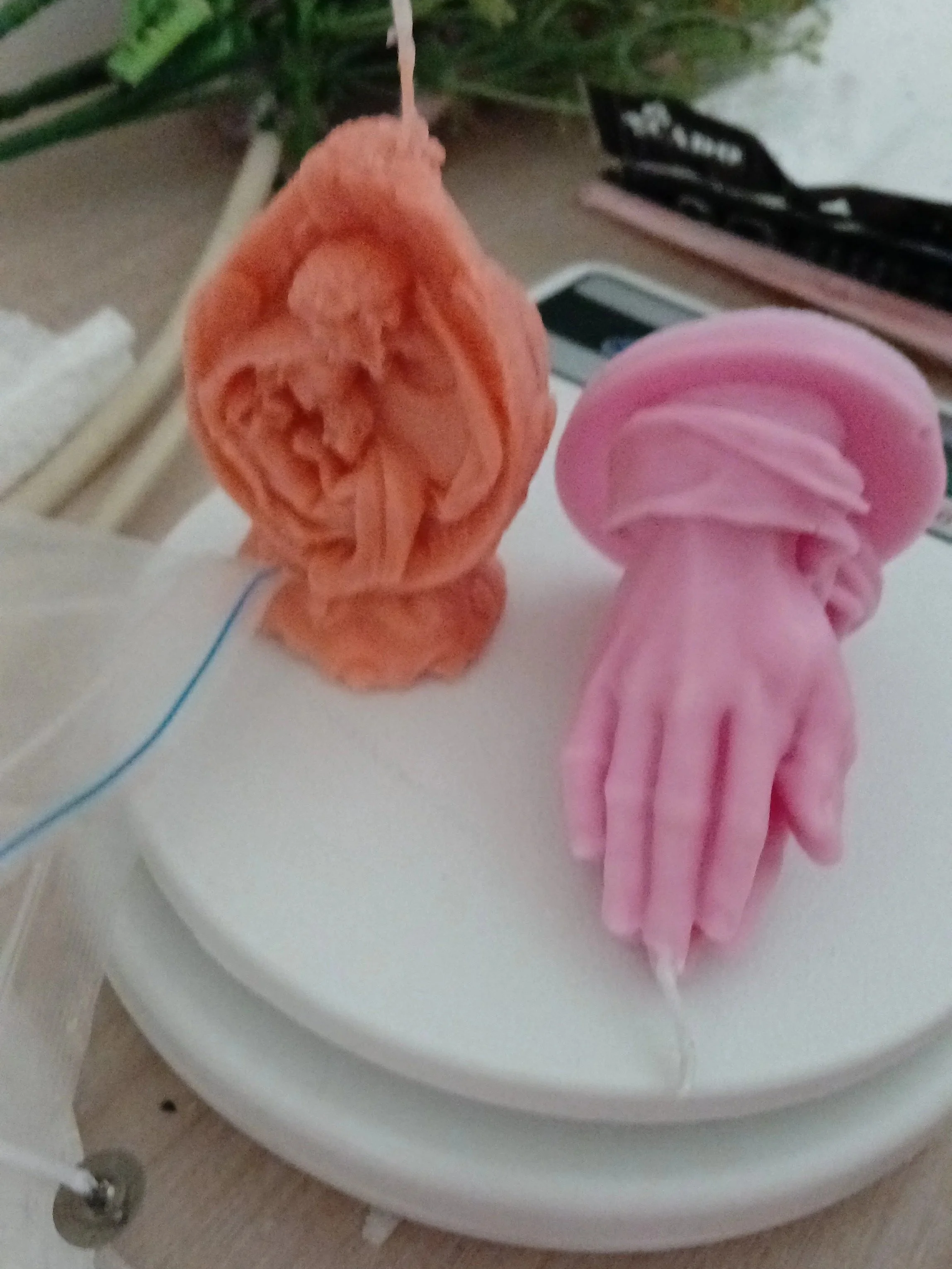 Un inodoro con un papel higiénico rosa y un papel de color anaranjado en la parte superior.