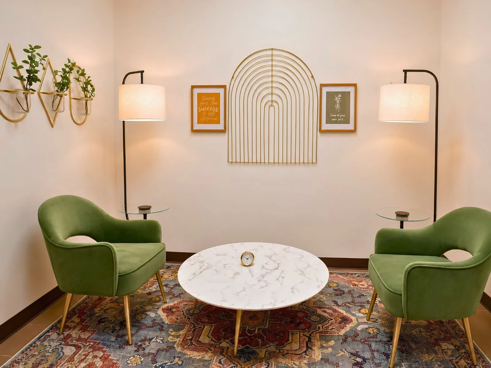 Cozy therapy room at Heartsease Counseling Center with two green velvet armchairs, marble coffee table, and gold arch wall decor.
