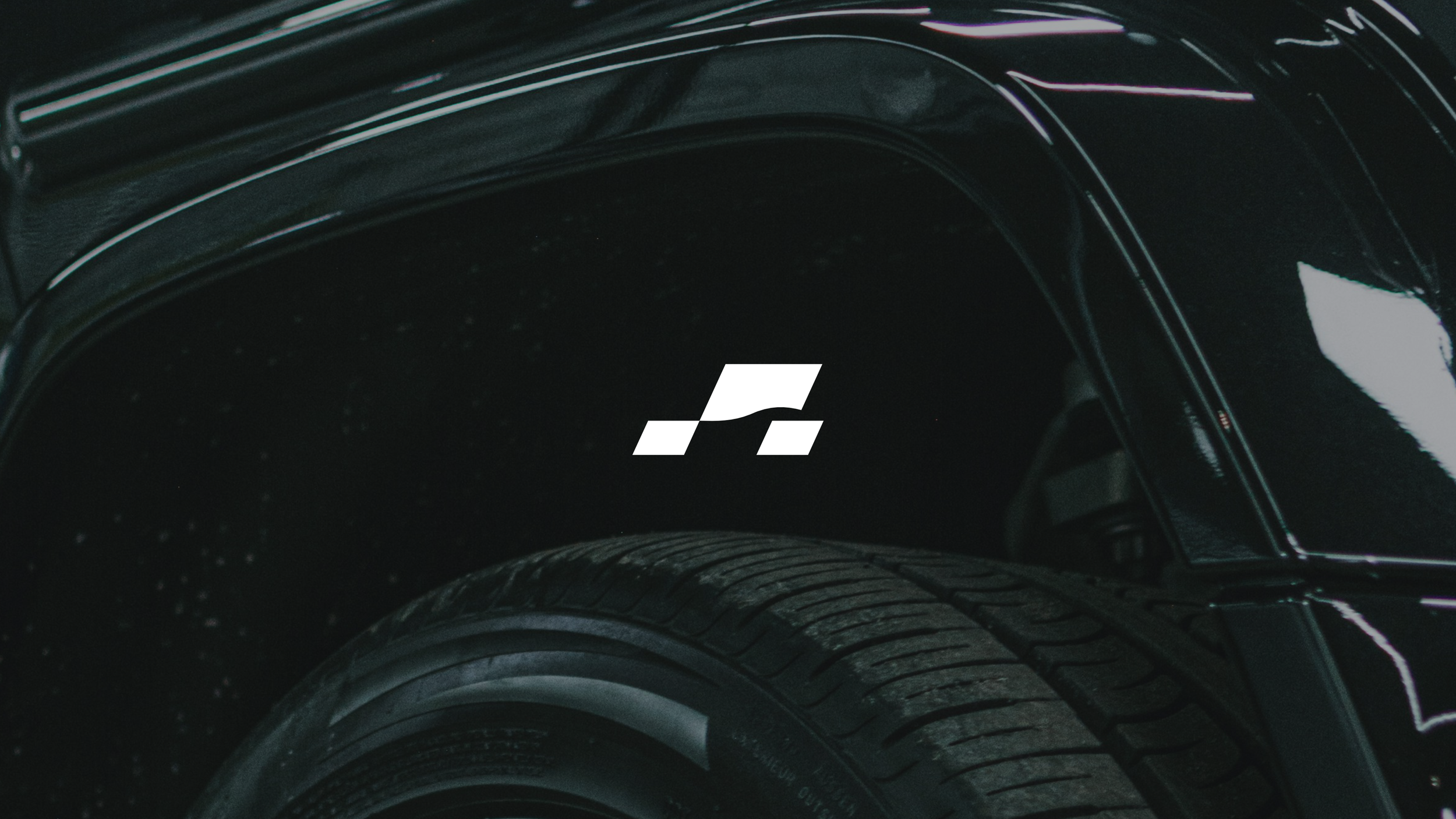 Nahaufnahme eines schwarzen Autoreifens mit einem weißen Logo in der Mitte.