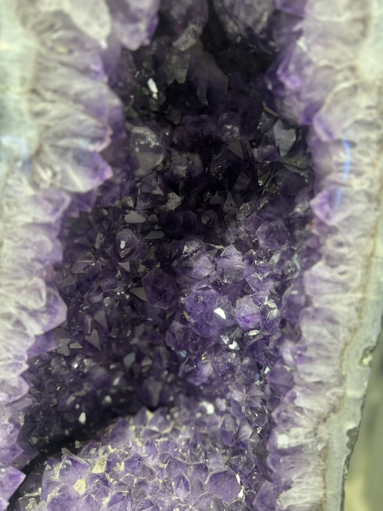 Close-up of a hollow space surrounded by purple and grayish crystalline rocks.