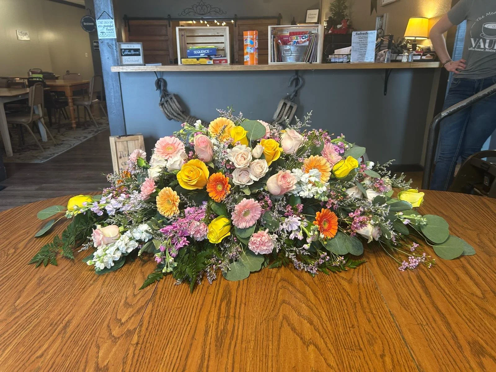 Large sized Caskey Spray ft bright gerbera daisies and yellow roses.