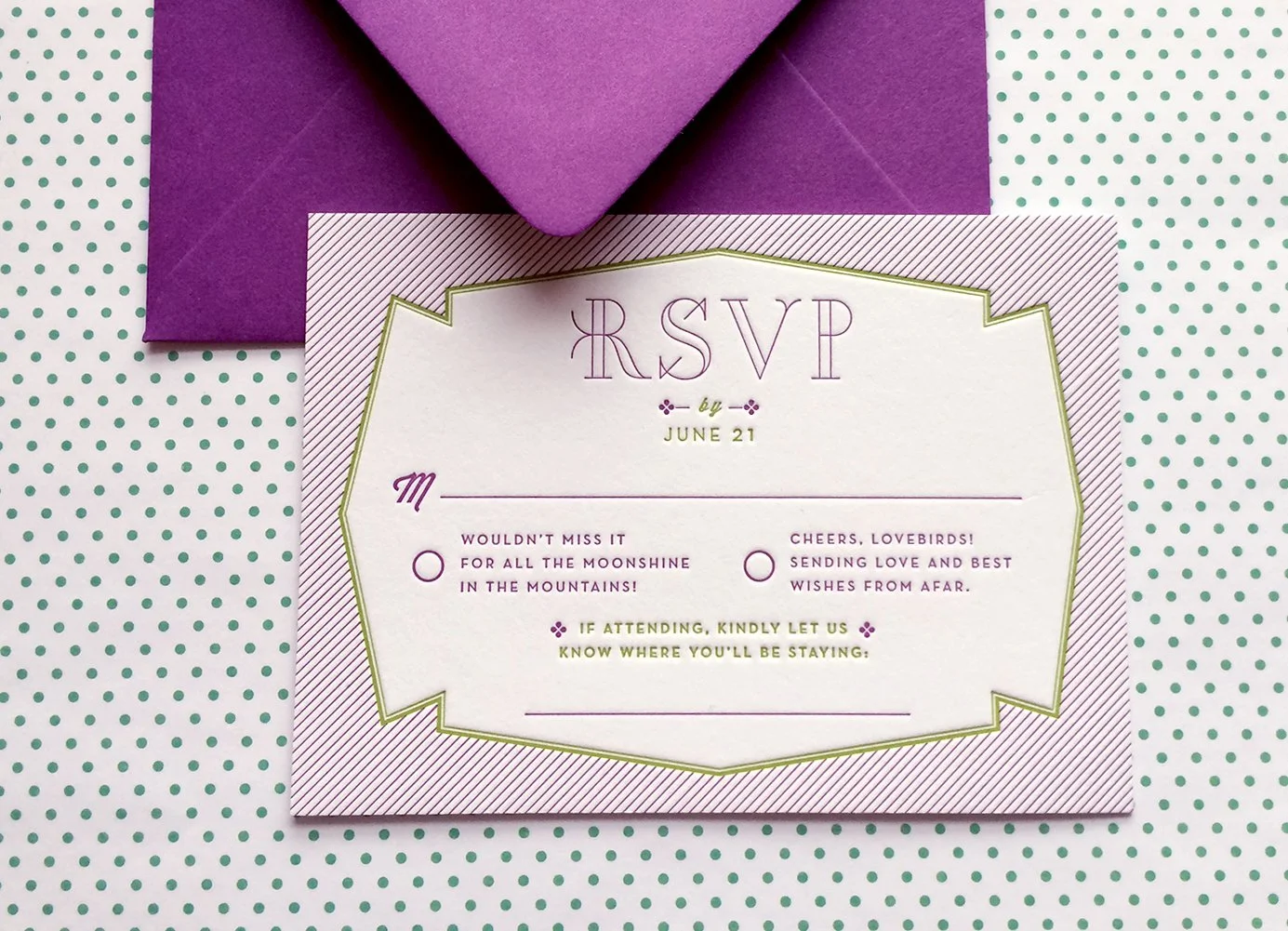 An RSVP card with purple and green accents, placed on green polka dot paper, accompanied by a purple envelope.