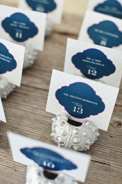 Table numbers and name tags for an event arranged in a row on a wooden table.
