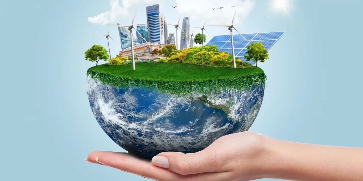 A hand holding a miniature Earth with a floating cityscape, wind turbines, and solar panels on top, symbolizing renewable energy and sustainability.