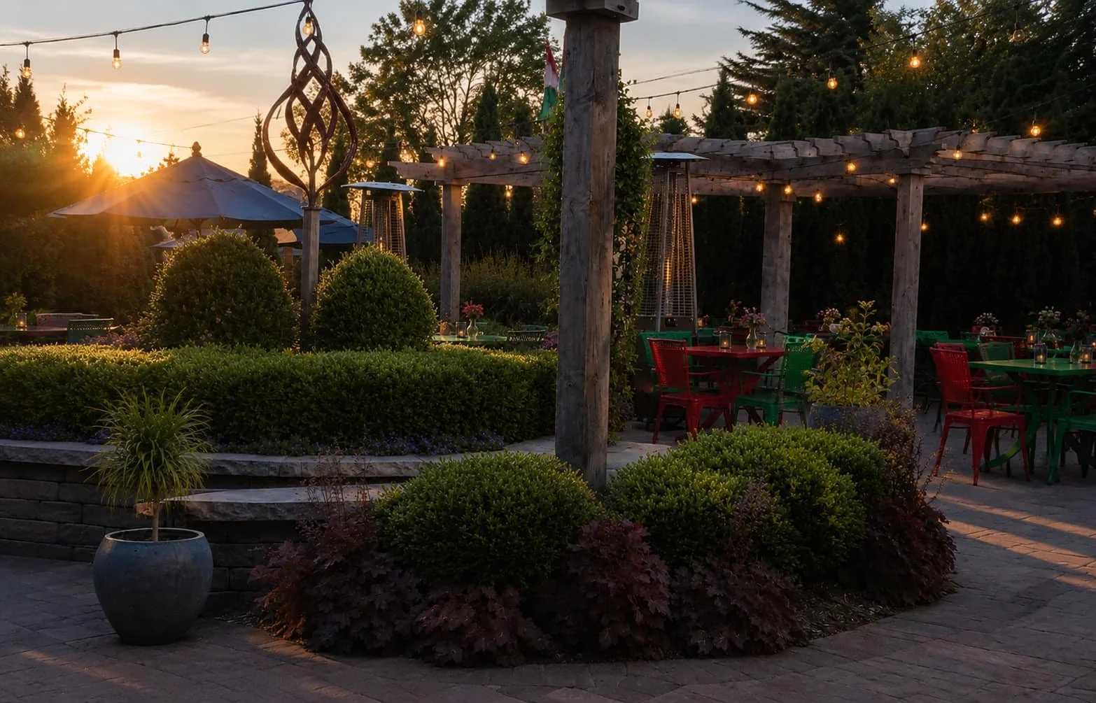 Golden hour patio at Tapas & Tacos Beer Garden with pergola, string lights, colorful seating, and landscaping at sunset in Lake Leelanau, Michigan