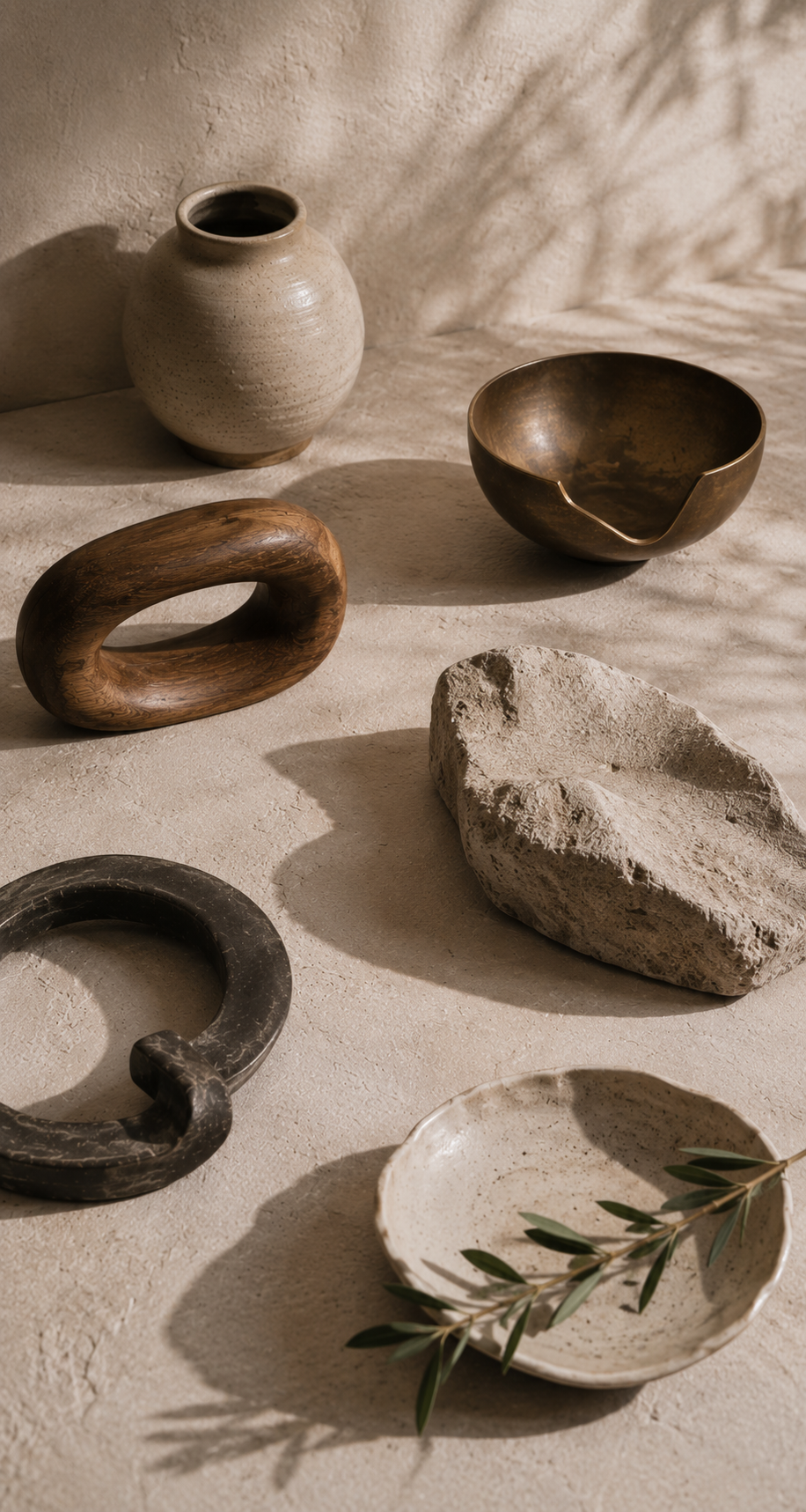 Distinct ceramic, wood, bronze, stone, and dark forms share an open sunlit space at varied distances, suggesting autonomy, interconnected relationships, and different ways of creating closeness.