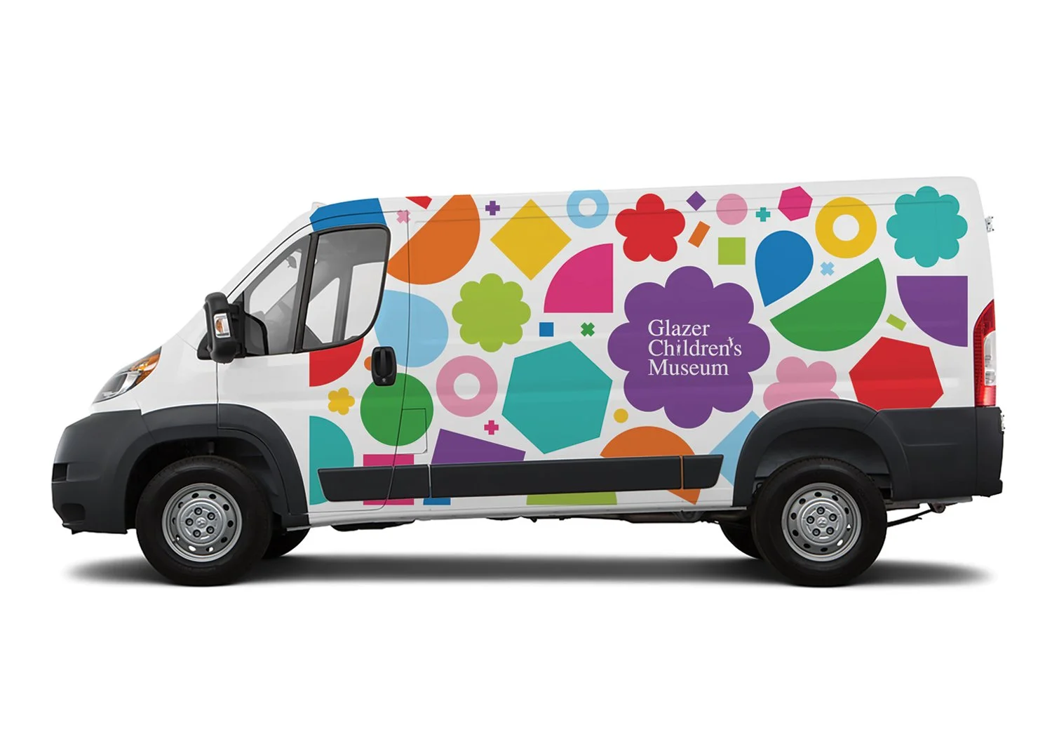 Glazer Children's Museum branded van wrap featuring a playful pattern of colorful geometric shapes like circles, diamonds, hexagons, flowers, and more in red, orange, yellow, green, teal, blue, pink, and purple on a white background. The museum logo 