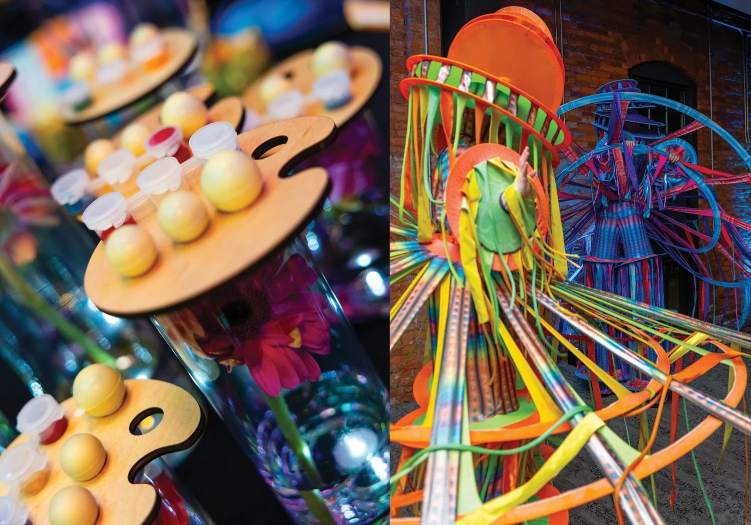 A close-up of artist palette–shaped table favors stacked with edible paint and truffles, paired with two performers in elaborate sculptural costumes made of layered rings and cascading colorful ribbons.
