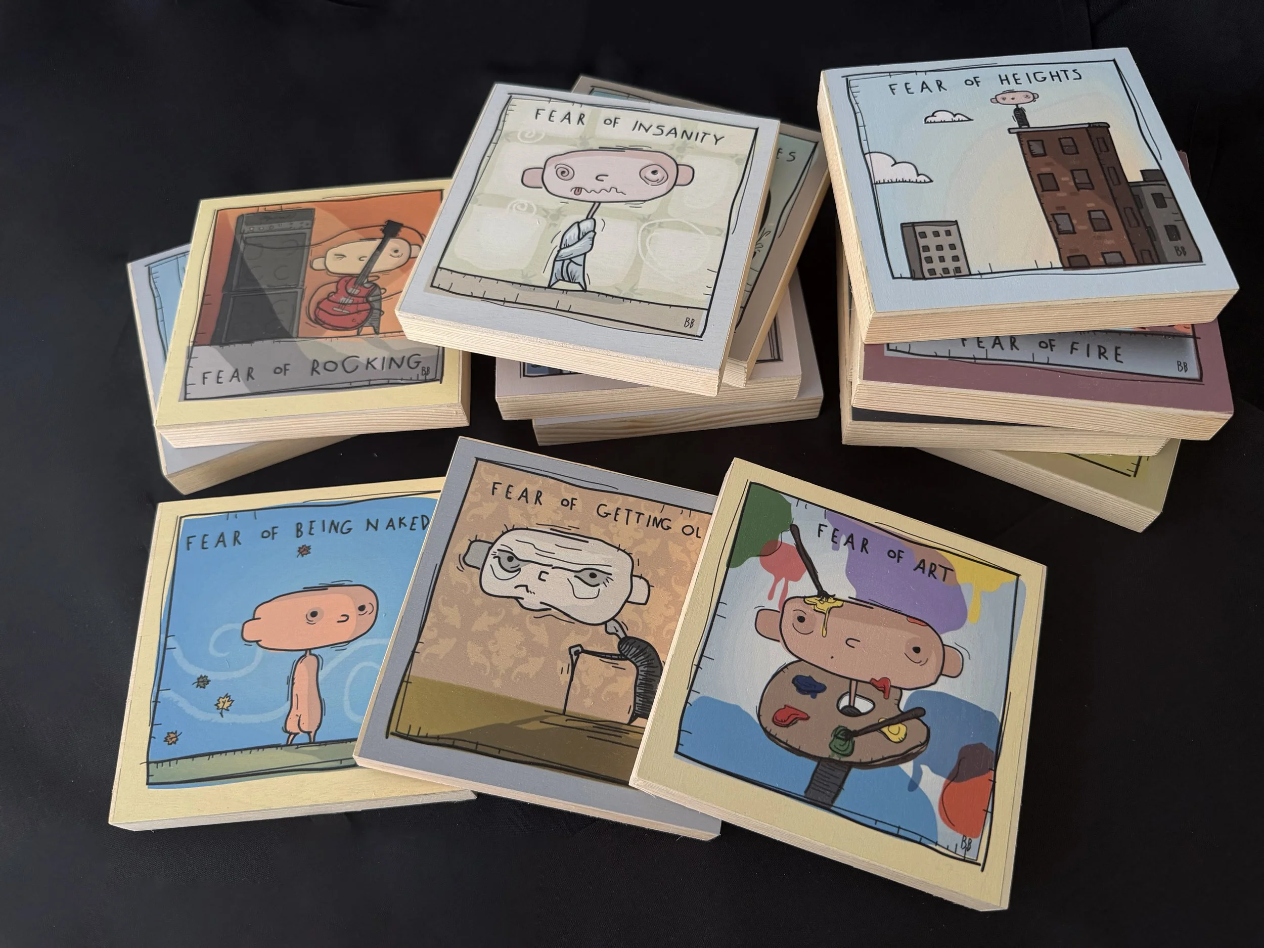 A collection of illustrated cards titled "Fear of..." with different humorous fears including fear of insanity, fear of heights, fear of rocking, fear of fire, fear of being naked, fear of getting old, and fear of art. The cards feature cartoon-style drawings of characters expressing these fears.