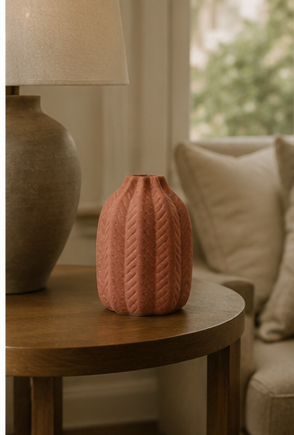 Pink decorative vase on wooden side table in living room.